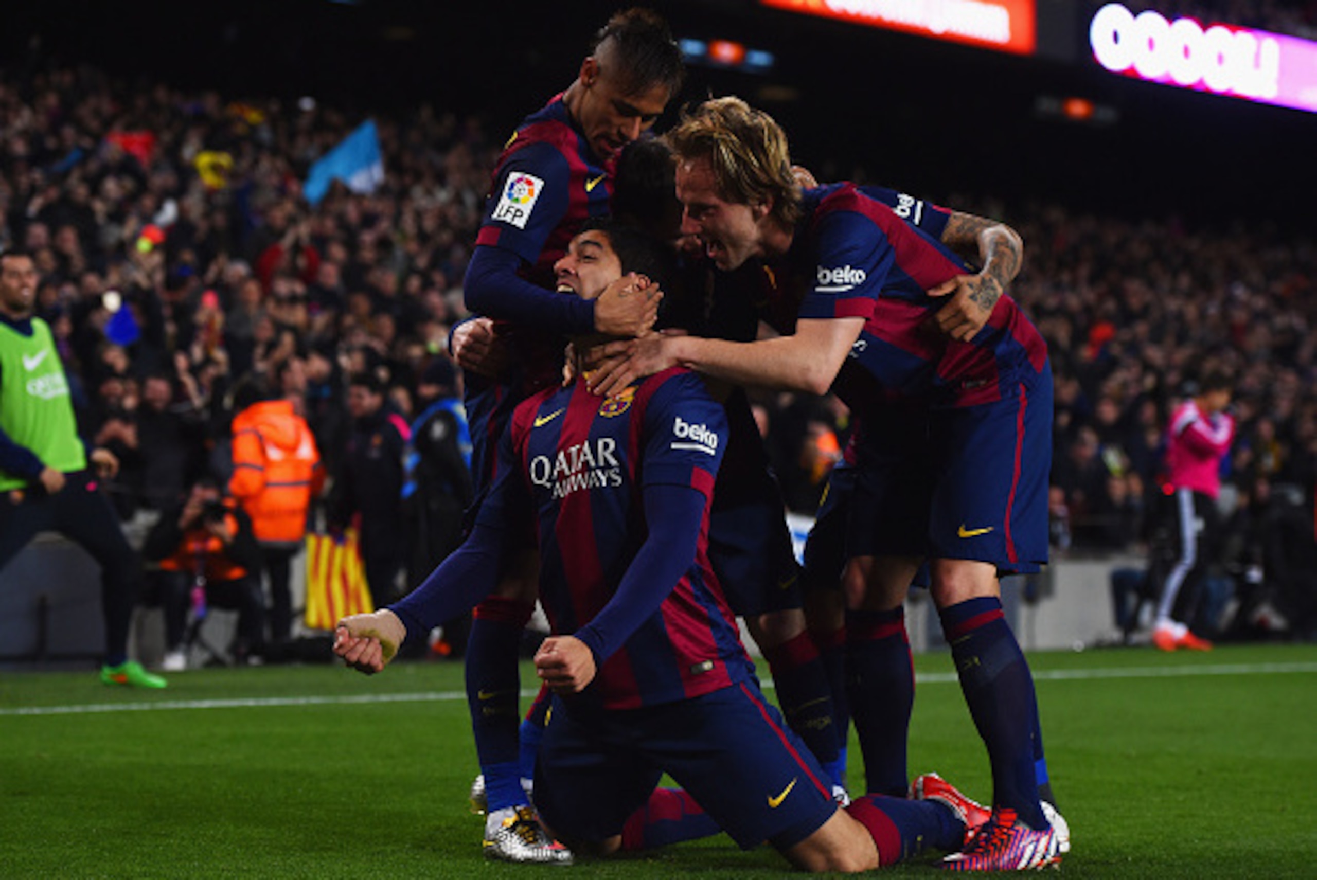 BARCELONA, SPAIN - MARCH 22:  Luis Suarez of Barcelona (grounded) celebrates with team mates as he scores their second goal during the La Liga match between FC Barcelona and Real Madrid CF at Camp Nou on March 22, 2015 in Barcelona, Spain.  (Photo by Davi