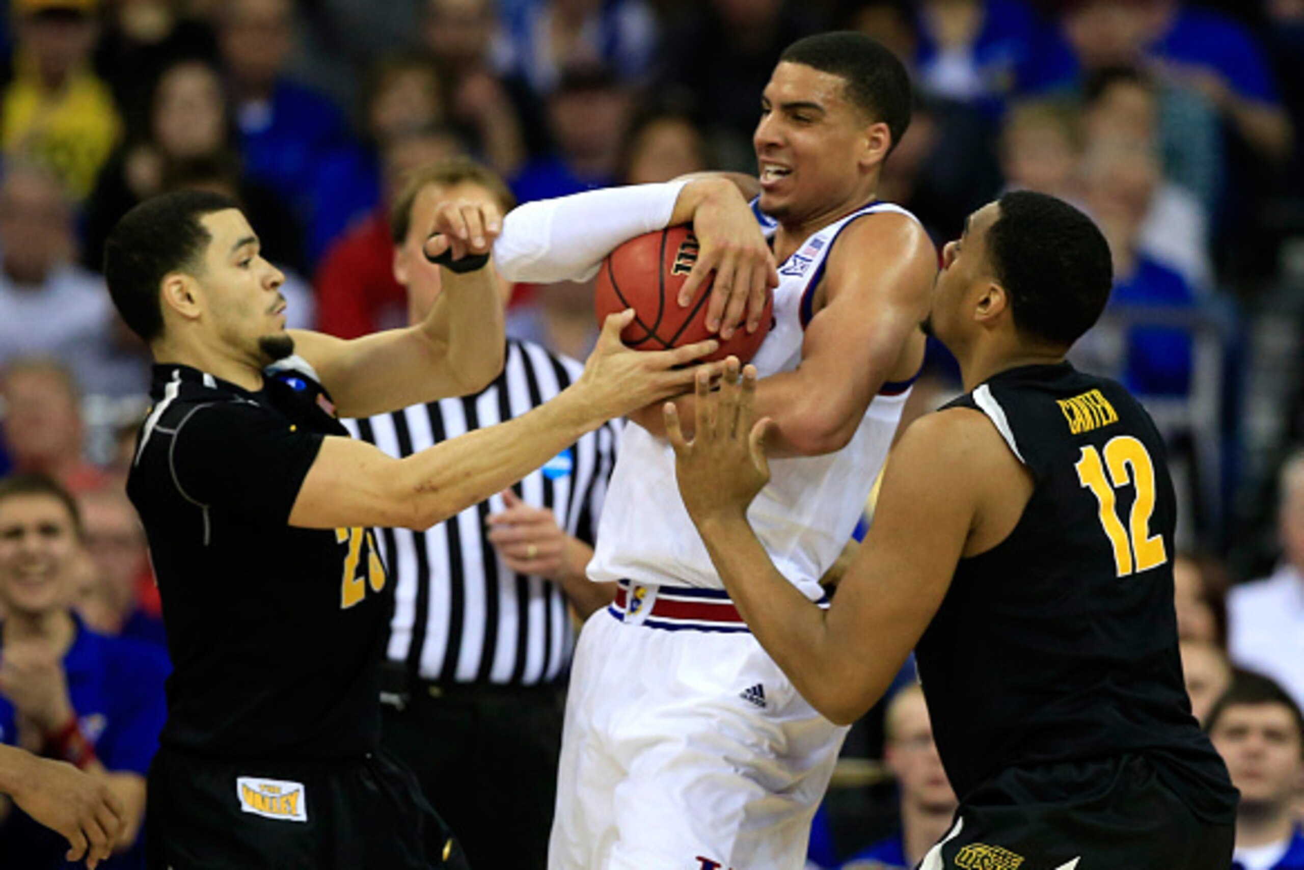 OMAHA, NE - MARCH 22:  Landen Lucas #33 of the Kansas Jayhawks is defended by Fred VanVleet #23 and teammate Darius Carter #12 of the Wichita State Shockers in the second half during the third round of the 2015 NCAA Men's Basketball Tournament at the Cent