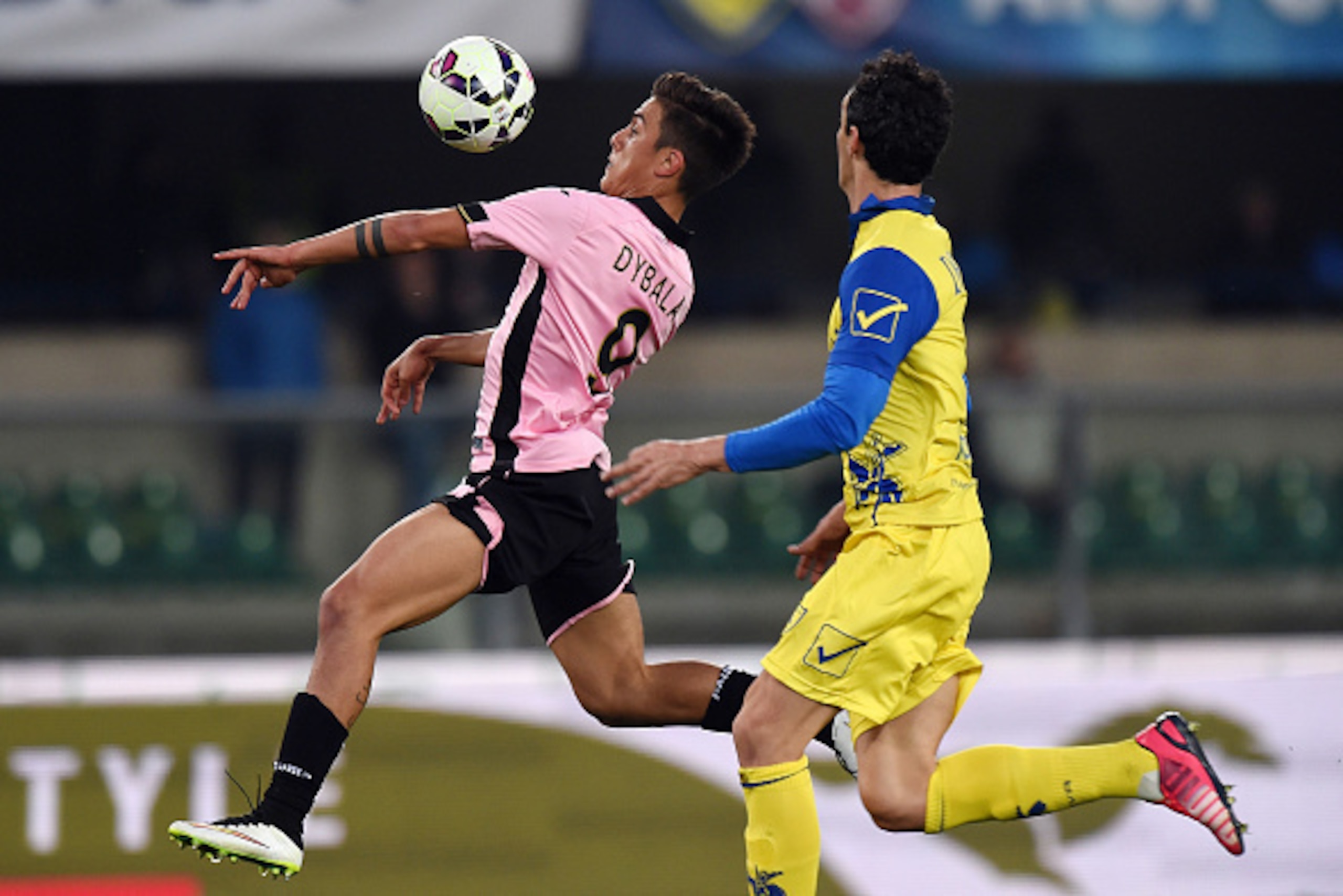 VERONA, ITALY - MARCH 21:  Paulo Dybala (L) of Palermo jumps for the ball as Dario Dainelli of Chievo tackles during the Serie A match between AC Chievo Verona and US Citta di Palermo at Stadio Marc'Antonio Bentegodi on March 21, 2015 in Verona, Italy.  (