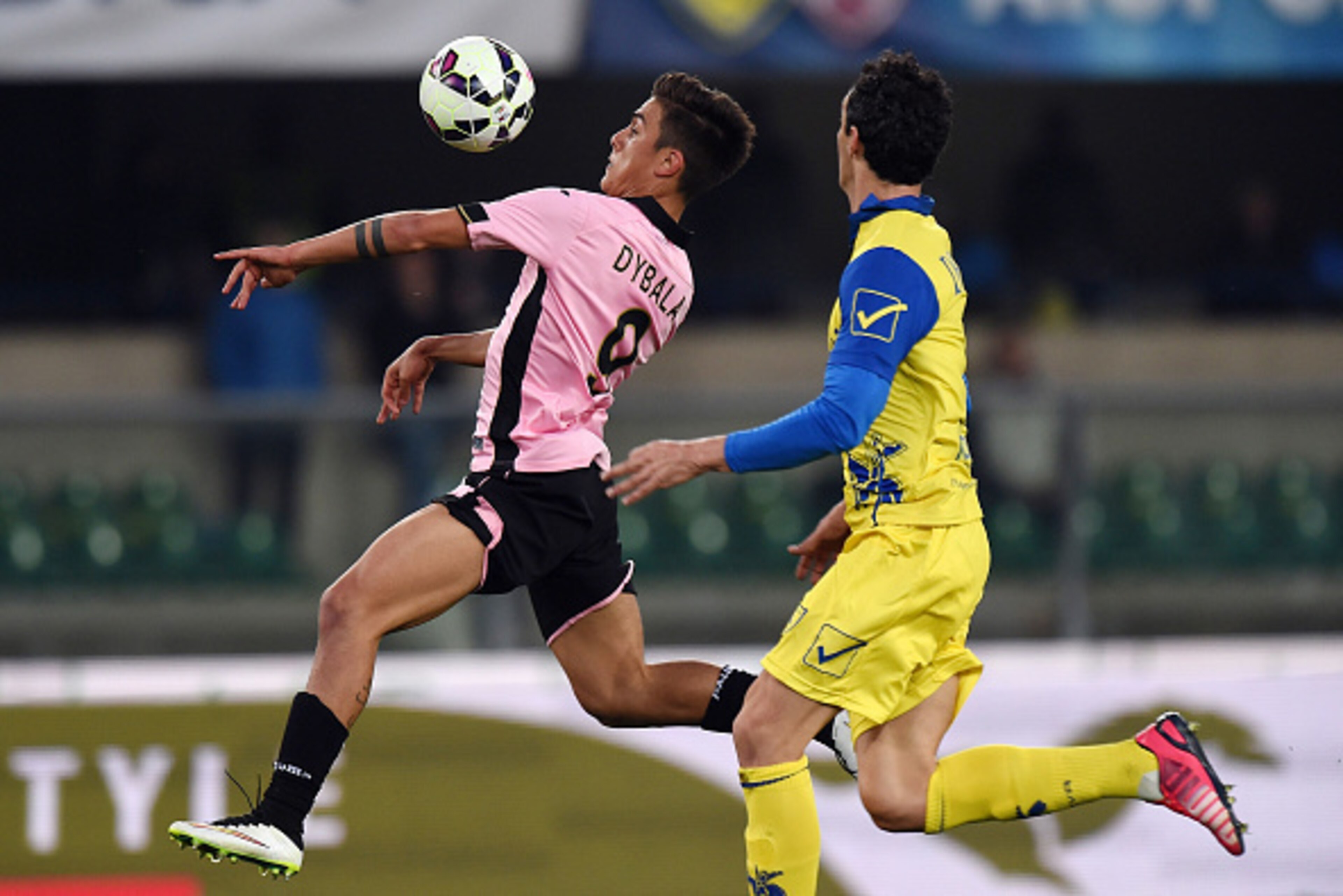 VERONA, ITALY - MARCH 21:  Paulo Dybala (L) of Palermo jumps for the ball as Dario Dainelli of Chievo tackles during the Serie A match between AC Chievo Verona and US Citta di Palermo at Stadio Marc'Antonio Bentegodi on March 21, 2015 in Verona, Italy.  (