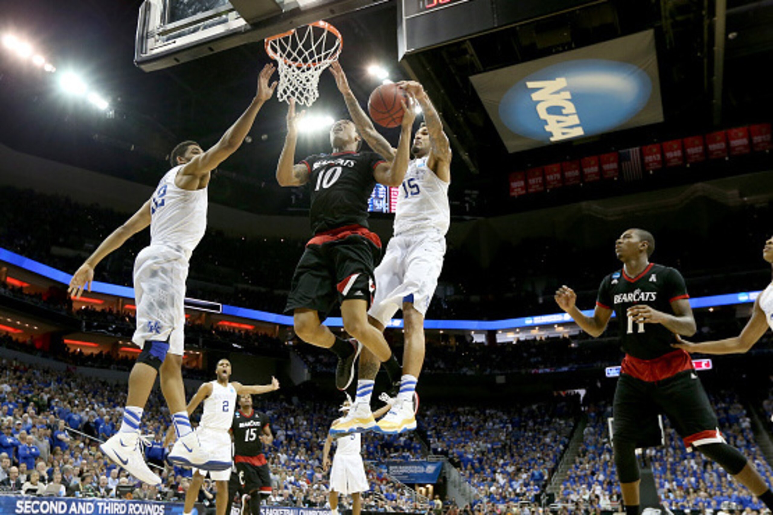 LOUISVILLE, KY - MARCH 21:  Troy Caupain #10 of the Cincinnati Bearcats drives to the basket against Willie Cauley-Stein #15 of the Kentucky Wildcats during the third round of the 2015 NCAA Men's Basketball Tournament at KFC YUM! Center on March 21, 2015 