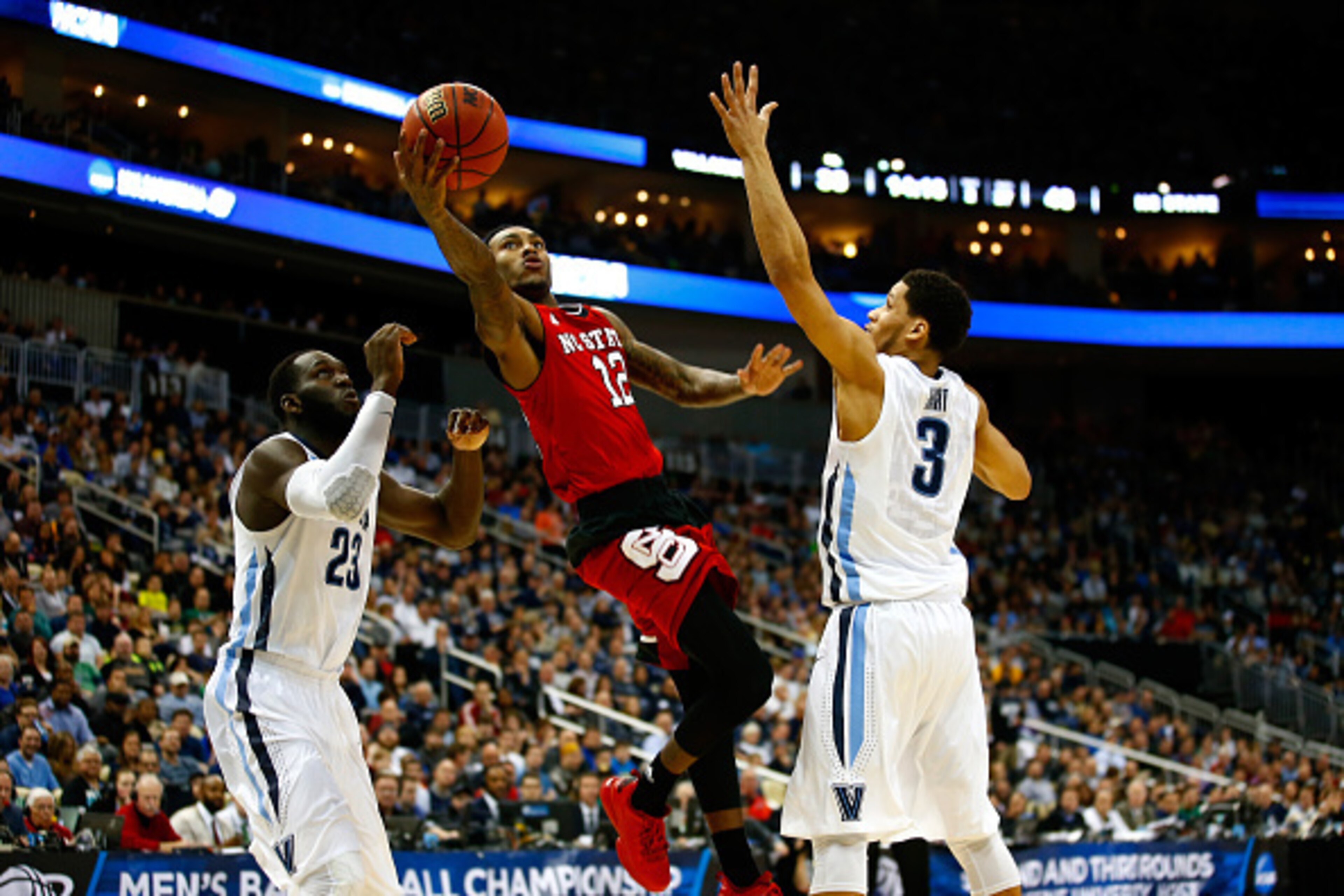 PITTSBURGH, PA - MARCH 21: Anthony Barber #12 of the North Carolina State Wolfpack puts up a shot in front of Daniel Ochefu #23 and Josh Hart #3 of the Villanova Wildcats in the second half during the third round of the 2015 NCAA Men's Basketball Tourname