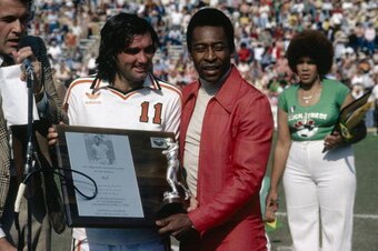 George Best presents Pele with a plaque commemorating the Brazilian as the best soccer player in the world during Pele Appreciation Day at Rose Bowl stadium in Pasedena, California, 9th April 1978. A friendly match was played between the Aztecs and Cosmos
