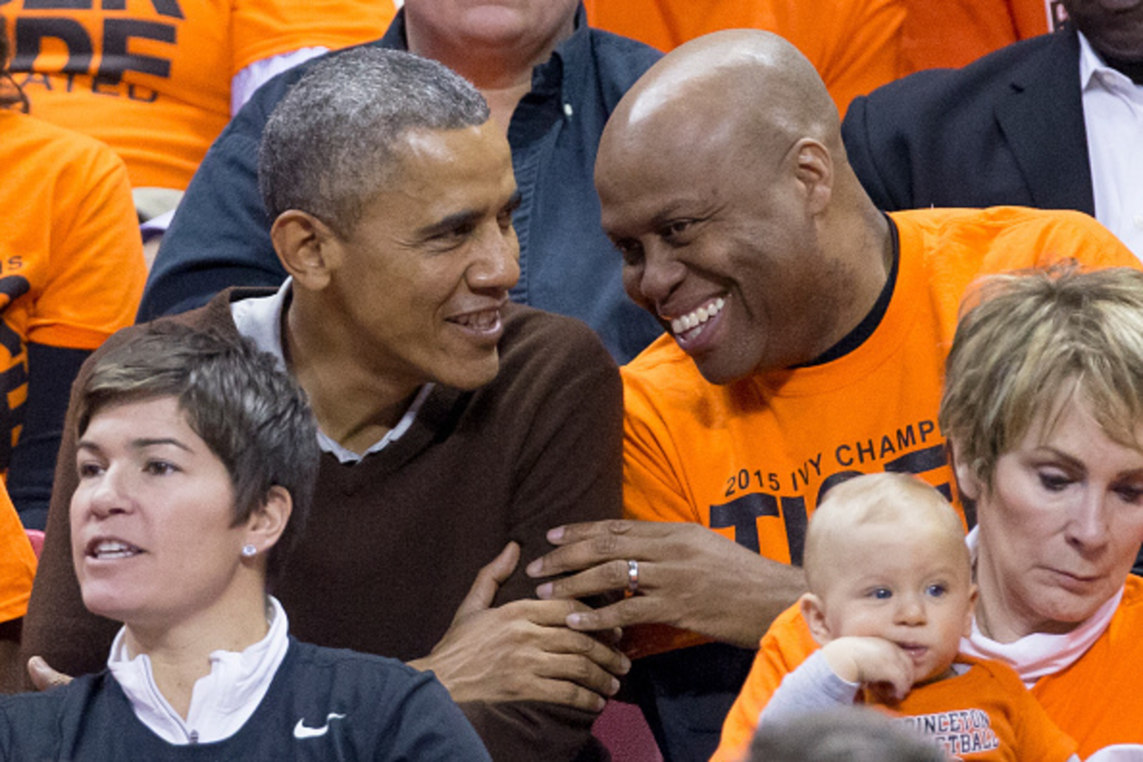 COLLEGE PARK, MD - MARCH 21:  (AFP OUT) U.S. President Barack Obama (L) sits beside his brother-in-law Craig Robinson while attending the Green Bay versus Princeton women's college basketball game in the first round of the NCAA tournament, March 21, 2015 