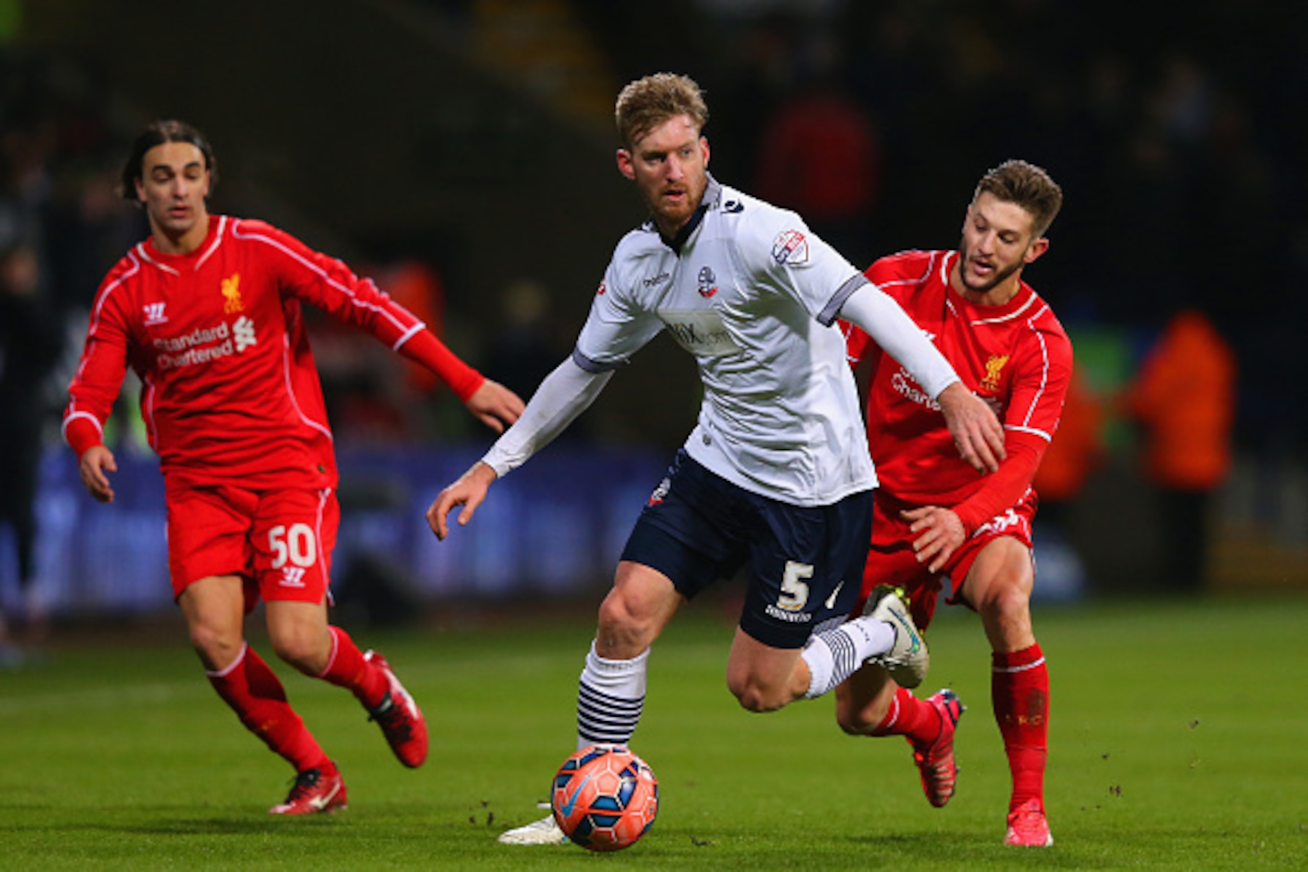 BOLTON, ENGLAND - FEBRUARY 04:  Tim Ream of Bolton Wanderers is marshalled by Adam Lallana of Liverpool during the FA Cup Fourth round replay between Bolton Wanderers and Liverpool at Macron Stadium on February 4, 2015 in Bolton, England.  (Photo by Alex 