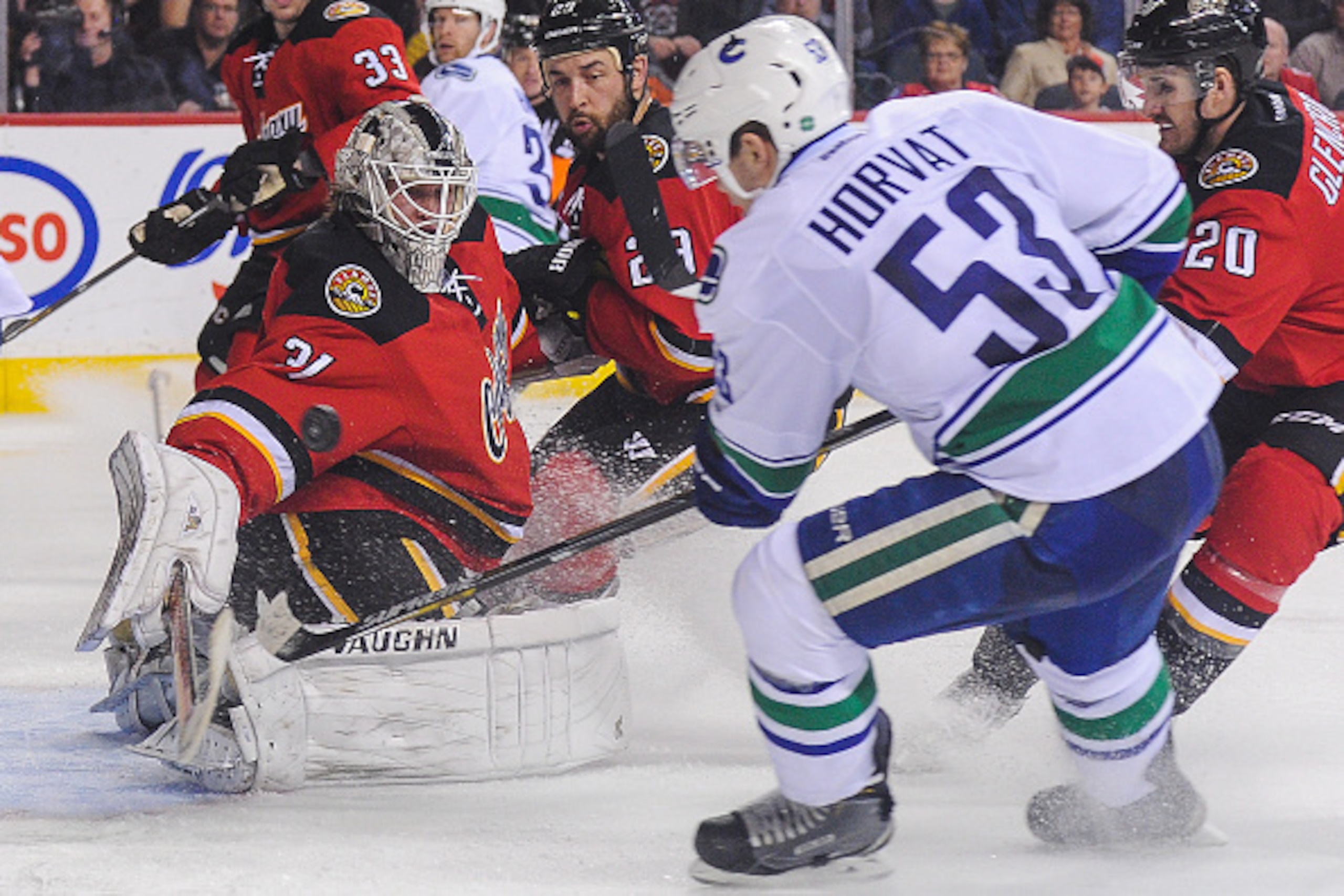 CALGARY, AB - FEBRUARY 14: Karri Ramo #31 of the Calgary Flames stops the shot of Bo Horvat #53 of the Vancouver Canucks during an NHL game at Scotiabank Saddledome on February 14, 2015 in Calgary, Alberta, Canada. The Flames defeated the Canucks 3-2. (Ph