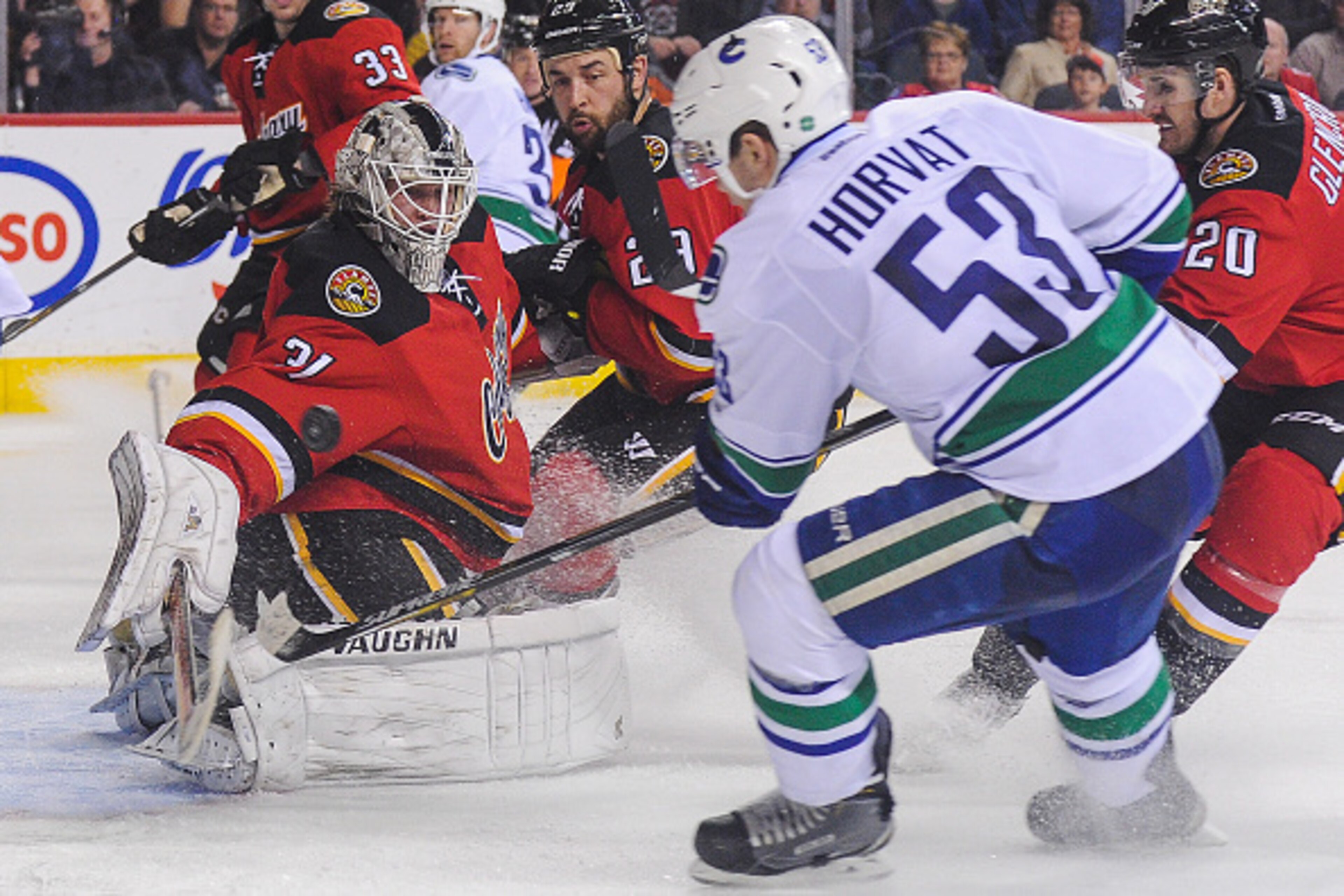 CALGARY, AB - FEBRUARY 14: Karri Ramo #31 of the Calgary Flames stops the shot of Bo Horvat #53 of the Vancouver Canucks during an NHL game at Scotiabank Saddledome on February 14, 2015 in Calgary, Alberta, Canada. The Flames defeated the Canucks 3-2. (Ph