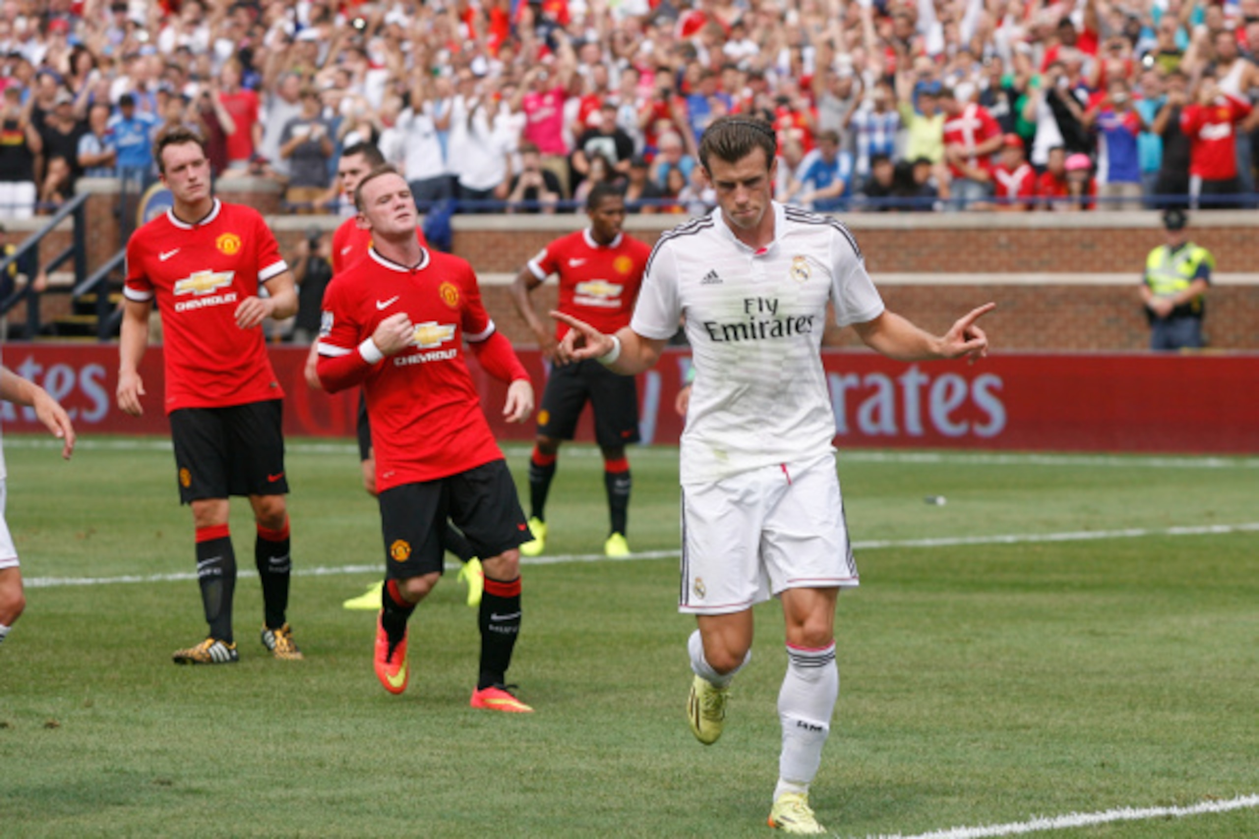 ANN ARBOR, MI - AUGUST 2: Gareth Bale #11 of Real Madrid celebrates his second half goal in front of Wayne Rooney #10 of Manchester United and Phil Jones #4 of Manchester United, left, during the second half of the Guinness International Champions Cup at 
