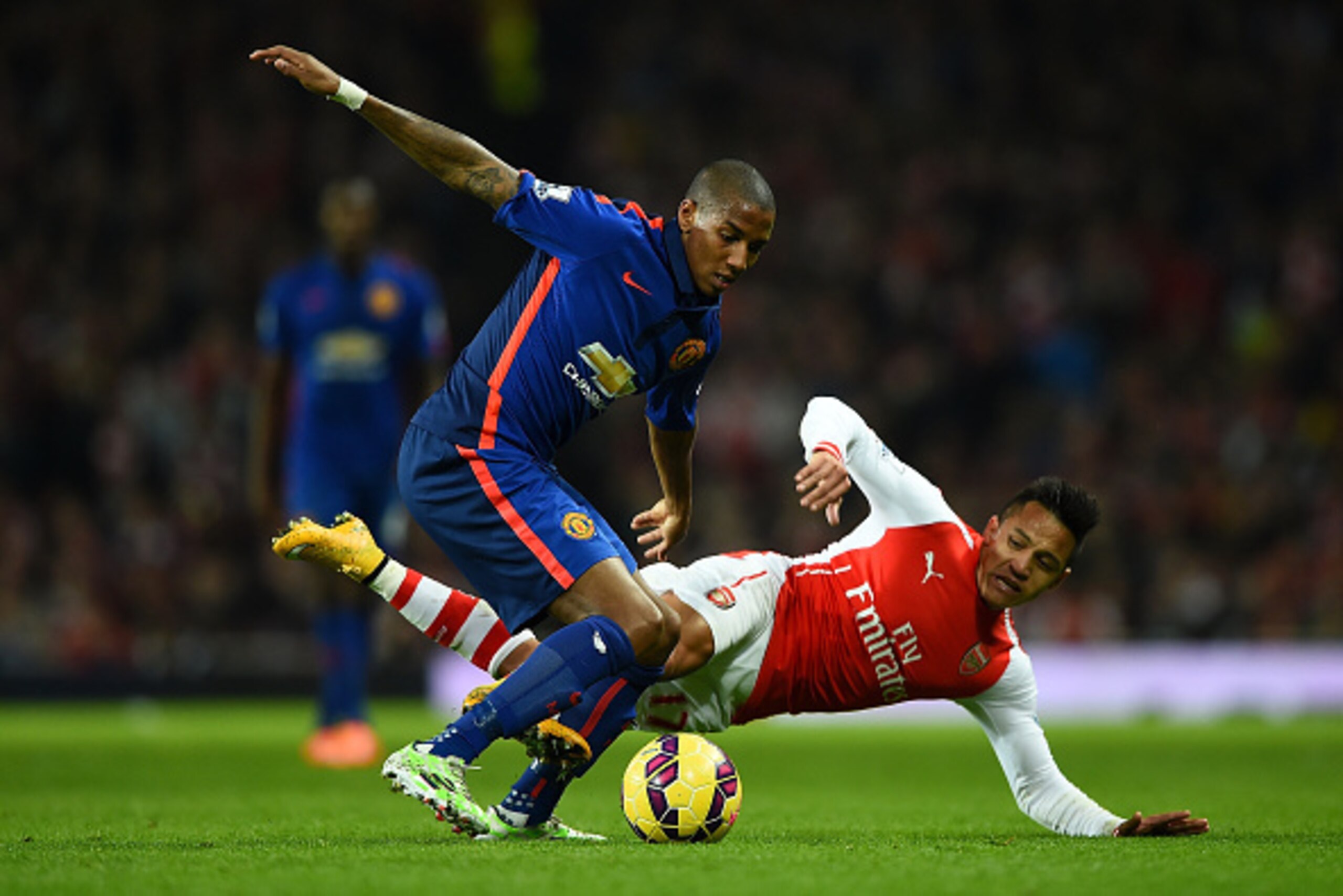 LONDON, ENGLAND - NOVEMBER 22: Ashley Young of Manchester United (L) tackles Alexis Sanchez of Arsenal   during the Barclays Premier League match between Arsenal and Manchester United at Emirates Stadium on November 22, 2014 in London, England. (Photo by 
