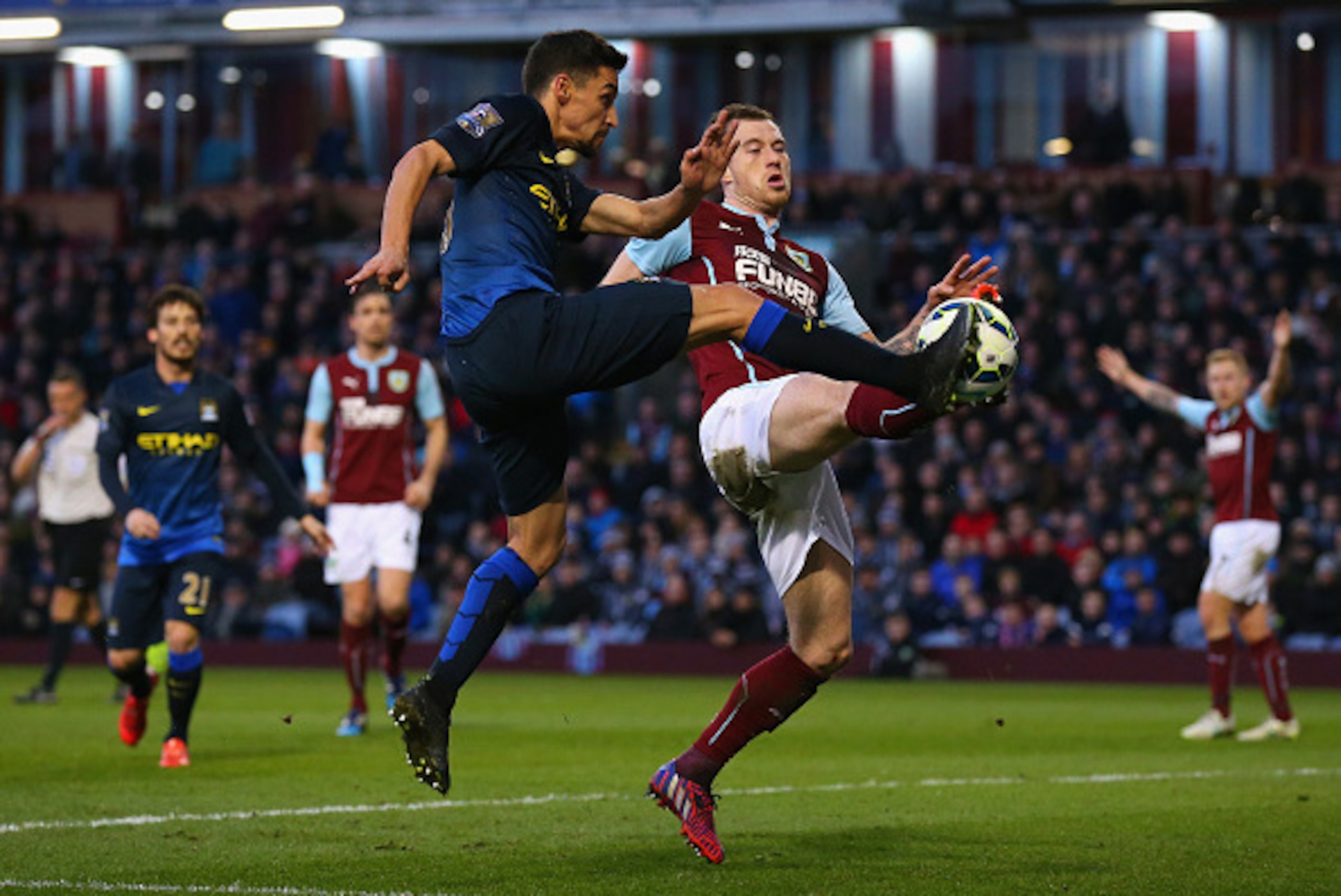 BURNLEY, ENGLAND - MARCH 14:  Jesus Navas of Manchester City is challenged by Ashley Barnes of Burnley  during the Barclays Premier League match between Burnley and Manchester City at Turf Moor on March 14, 2015 in Burnley, England.  (Photo by Alex Livese