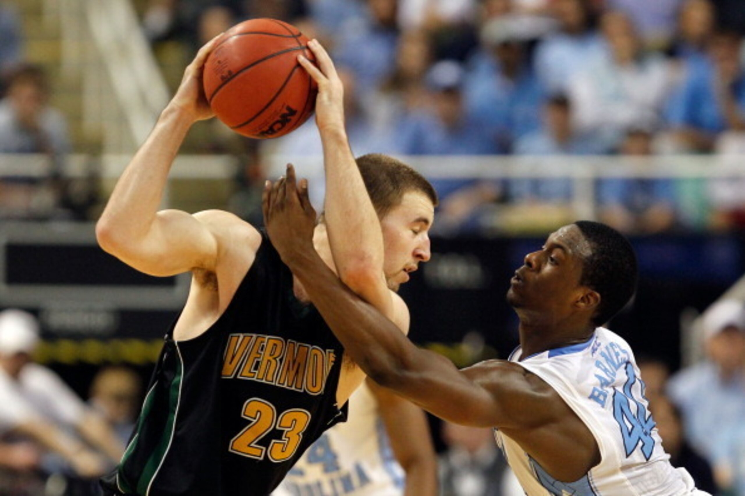 GREENSBORO, NC - MARCH 16:  Brian Voelkel #23 of the Vermont Catamounts handles the ball against Harrison Barnes #40 of the North Carolina Tar Heels during the second round of the 2012 NCAA Men's Basketball Tournament at Greensboro Coliseum on March 16, 2