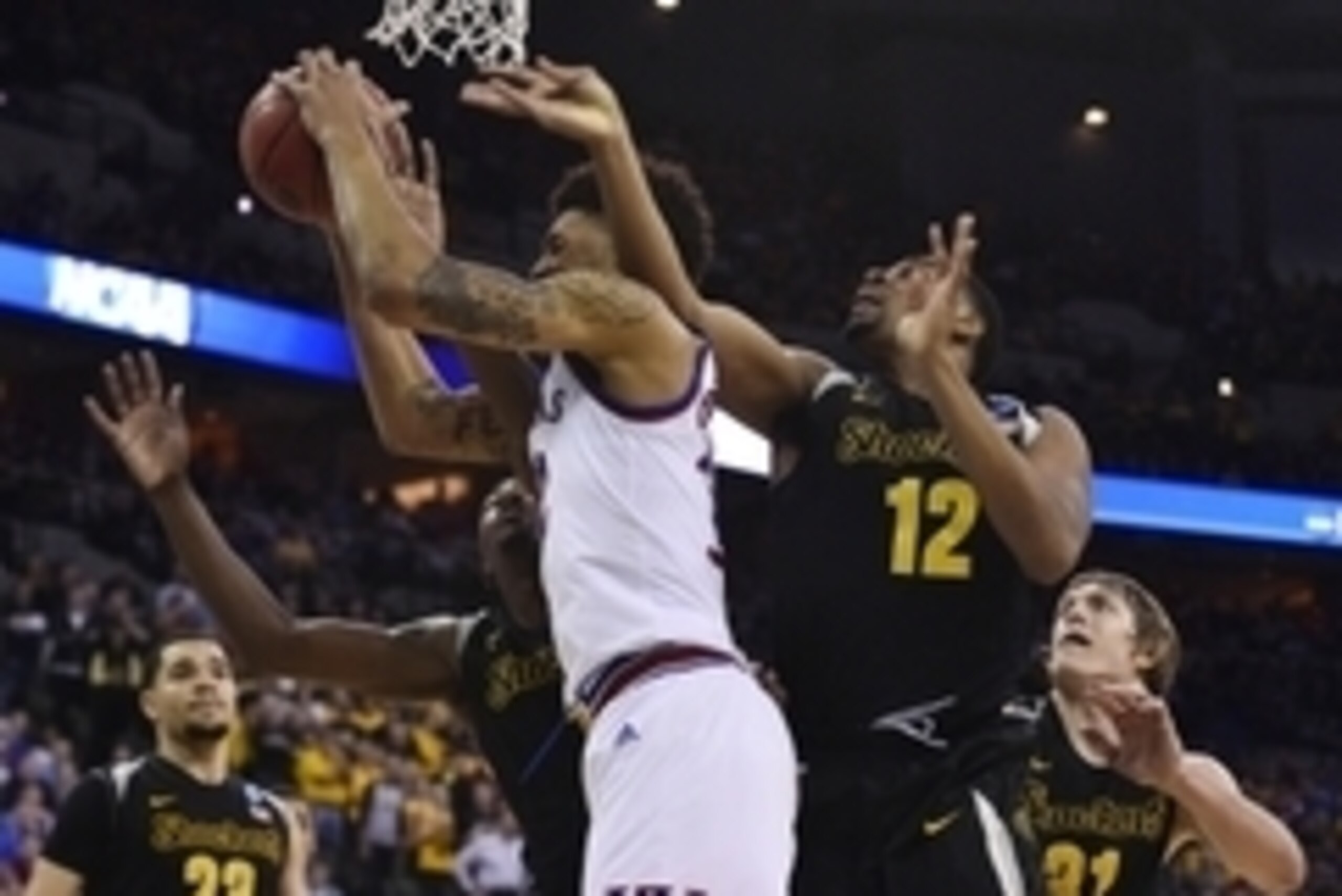 Mar 22, 2015; Omaha, NE, USA; Kansas Jayhawks guard Kelly Oubre Jr. (middle) attempts a shot against Wichita State Shockers forward Darius Carter (12) during the second half in the third round of the 2015 NCAA Tournament at CenturyLink Center. Mandatory C