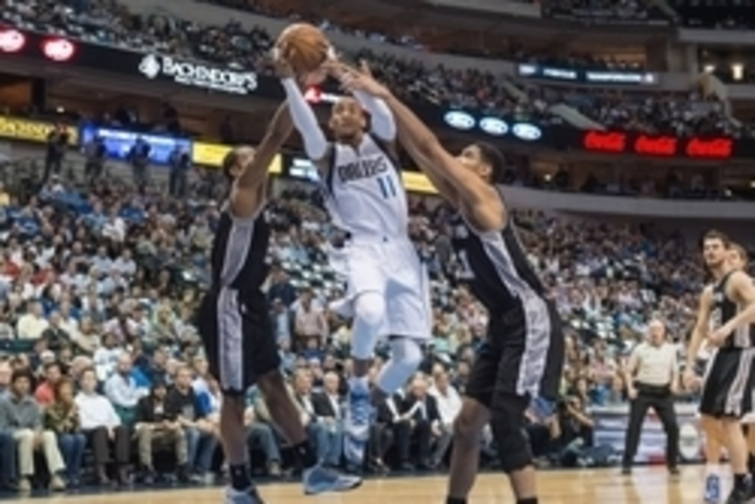 Mar 24, 2015; Dallas, TX, USA; Dallas Mavericks guard Monta Ellis (11) drives to the basket past San Antonio Spurs forward Kawhi Leonard (2) and forward Tim Duncan (21) during the first quarter at the American Airlines Center. Mandatory Credit: Jerome Mir