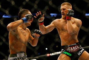 BOSTON, MA - AUGUST 17: Conor McGregor punches Max Holloway in their featherweight bout at TD Garden on August 17, 2013 in Boston, Massachusetts. (Photo by Jared Wickerham/Getty Images)