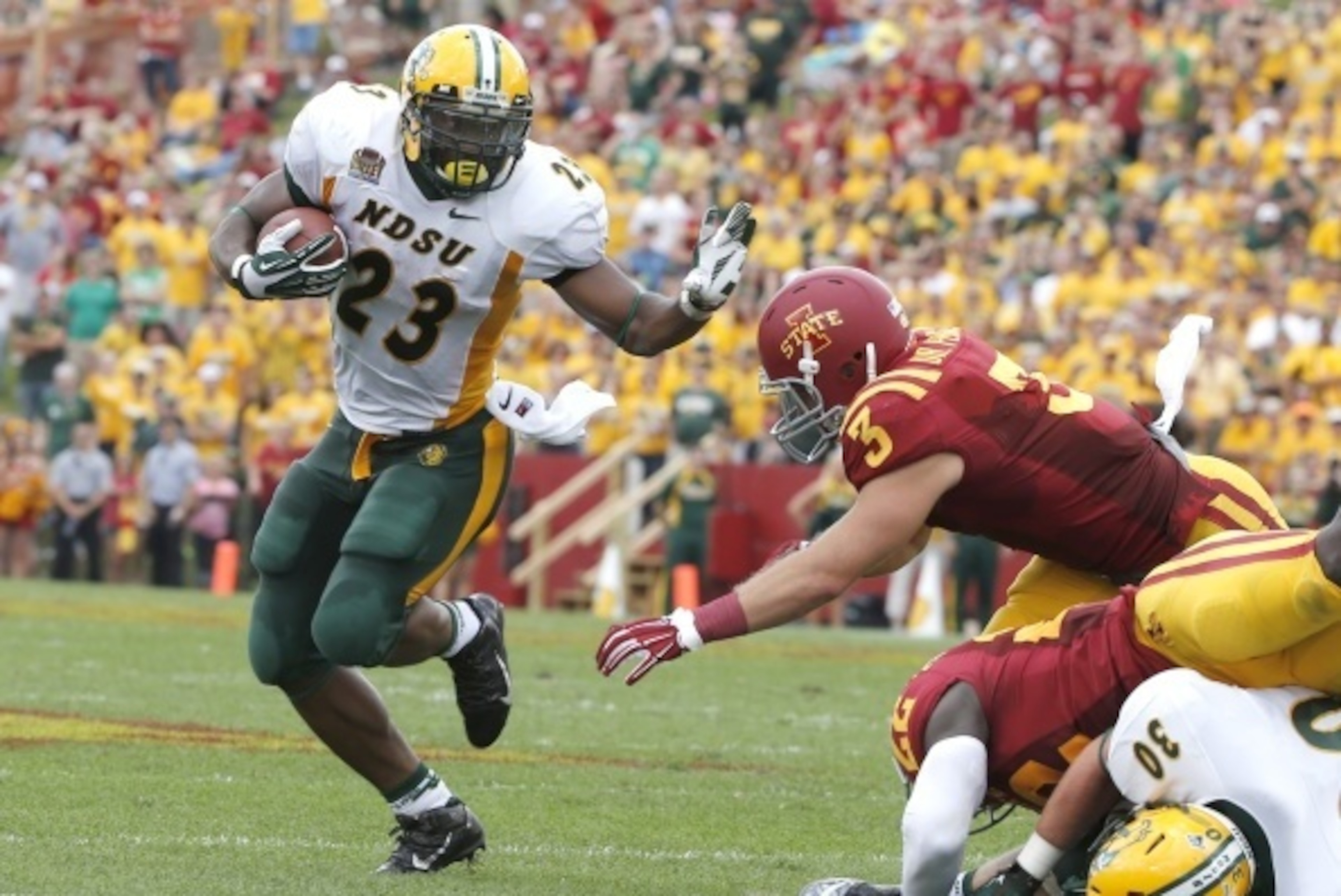 AMES, IA - AUGUST 30: Running back John Crockett #23 of the North Dakota State Bison rushes for yards past linebacker Drake Ferch #3 of the Iowa State Cyclones in the first half of play at Jack Trice Stadium on August 30, 2014 in Ames, Iowa. (Photo by Dav