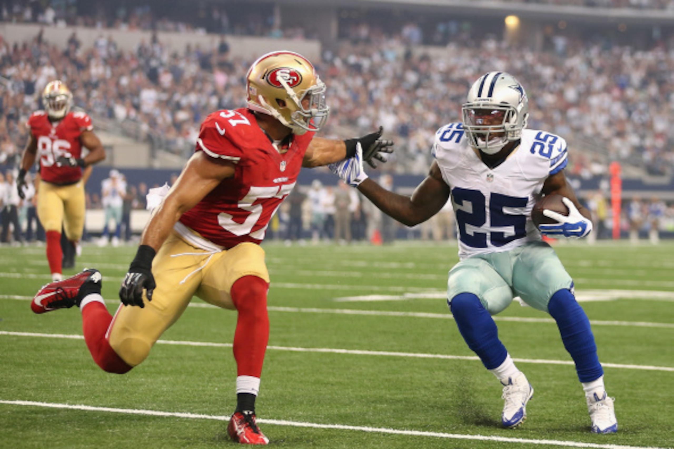 ARLINGTON, TX - SEPTEMBER 07:  Running back Lance Dunbar #25 of the Dallas Cowboys rushes the football against inside linebacker Michael Wilhoite #57 of the San Francisco 49ers during the NFL game at AT&T Stadium on September 7, 2014 in Arlington, Texas. 