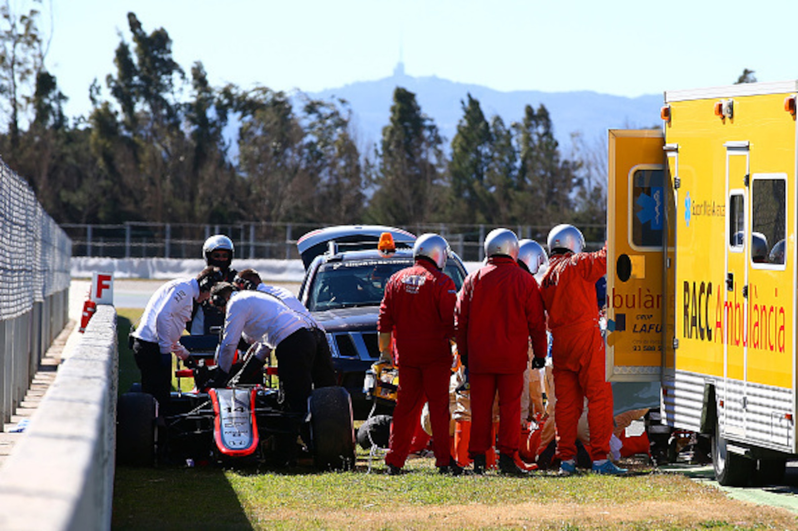 MONTMELO, SPAIN - FEBRUARY 22:  Fernando Alonso of Spain and McLaren Honda receives medical assistance after crashing during day four of Formula One Winter Testing at Circuit de Catalunya on February 22, 2015 in Montmelo, Spain.  (Photo by Mark Thompson/G