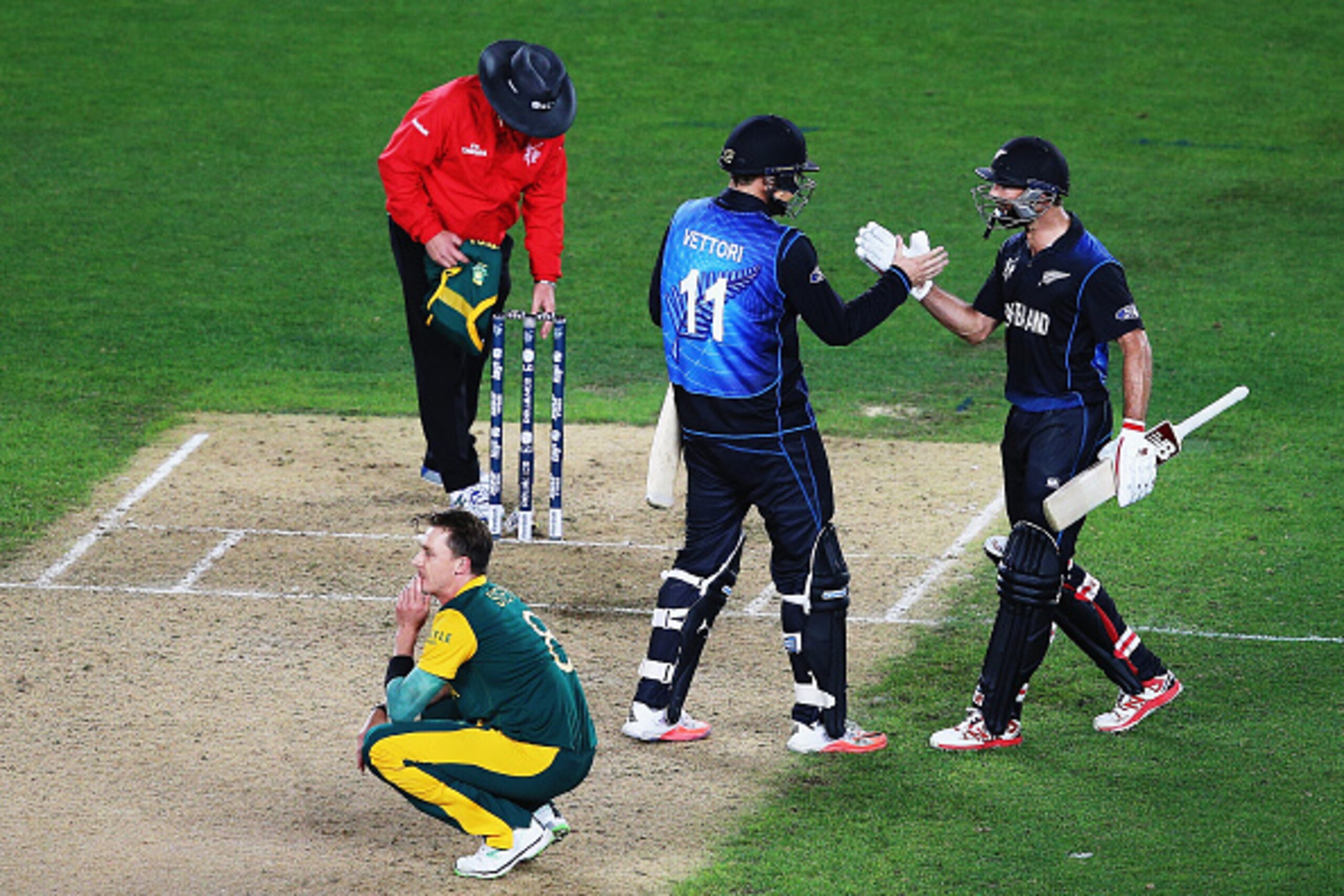 AUCKLAND, NEW ZEALAND - MARCH 24:  Dale Steyn of South Africa looks on as Daniel Vettori of New Zealand and Grant Elliott of New Zealand celebrate winning the 2015 Cricket World Cup Semi Final match between New Zealand and South Africa at Eden Park on Mar