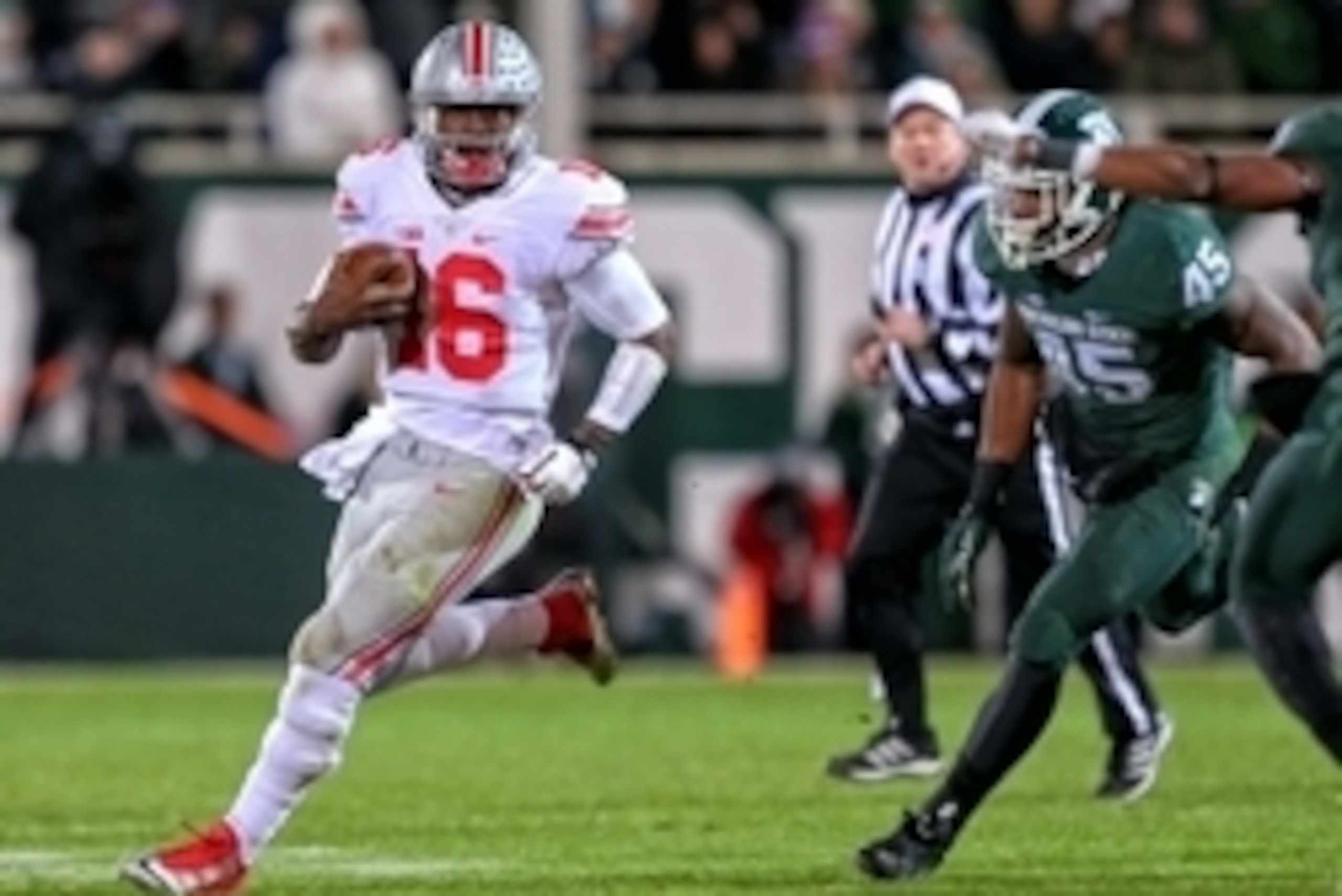 Nov 8, 2014; East Lansing, MI, USA; Ohio State Buckeyes quarterback J.T. Barrett (16) gets outside of Michigan State Spartans linebacker Darien Harris (45) during the 2nd half of a game at Spartan Stadium. Mandatory Credit: Mike Carter-USA TODAY Sports