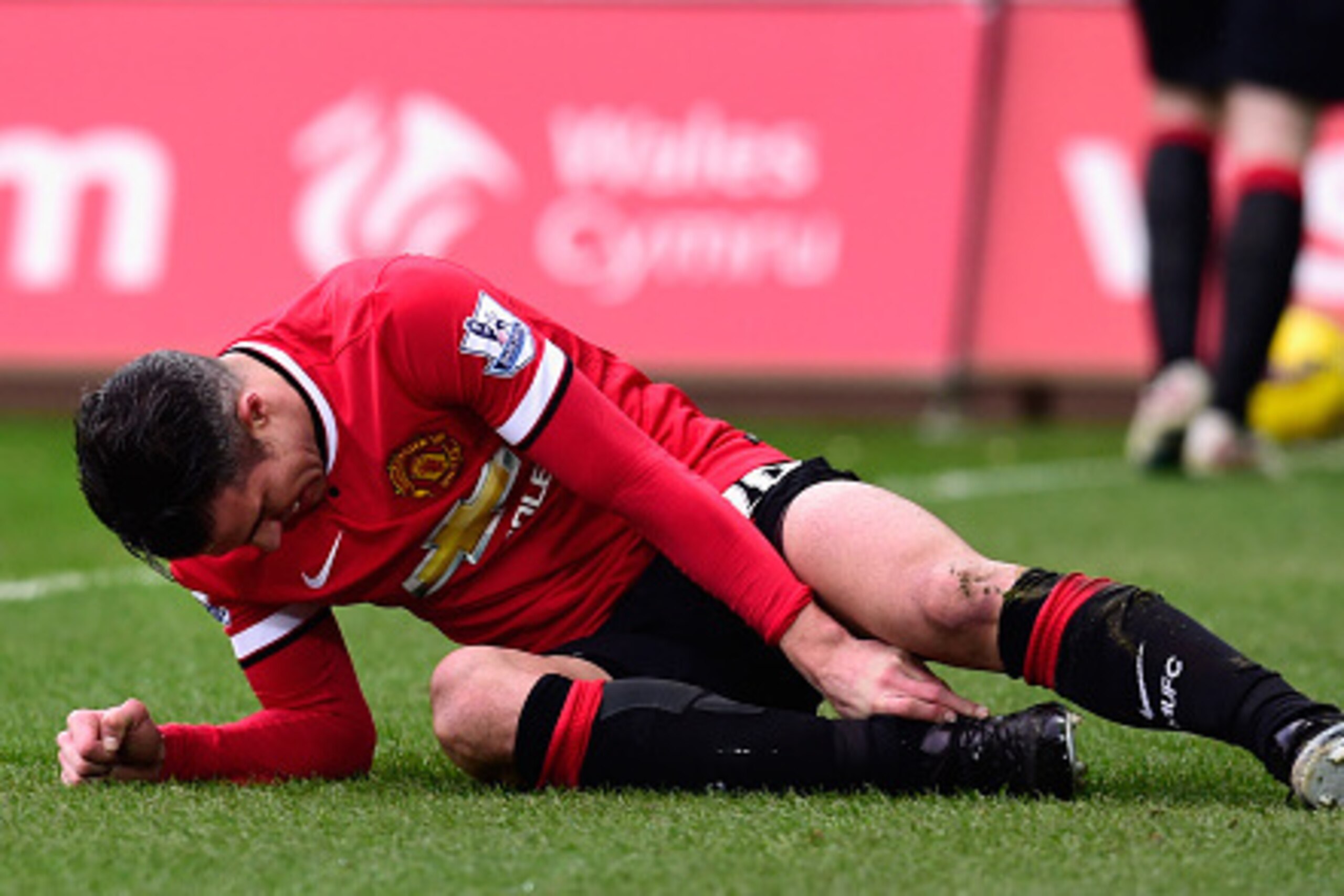 SWANSEA, WALES - FEBRUARY 21:  Robin Van Persie  of Manchester United lies injured during the Barclays Premier League match between Swansea City and Manchester United at Liberty Stadium on February 21, 2015 in Swansea, Wales.  (Photo by Stu Forster/Getty 