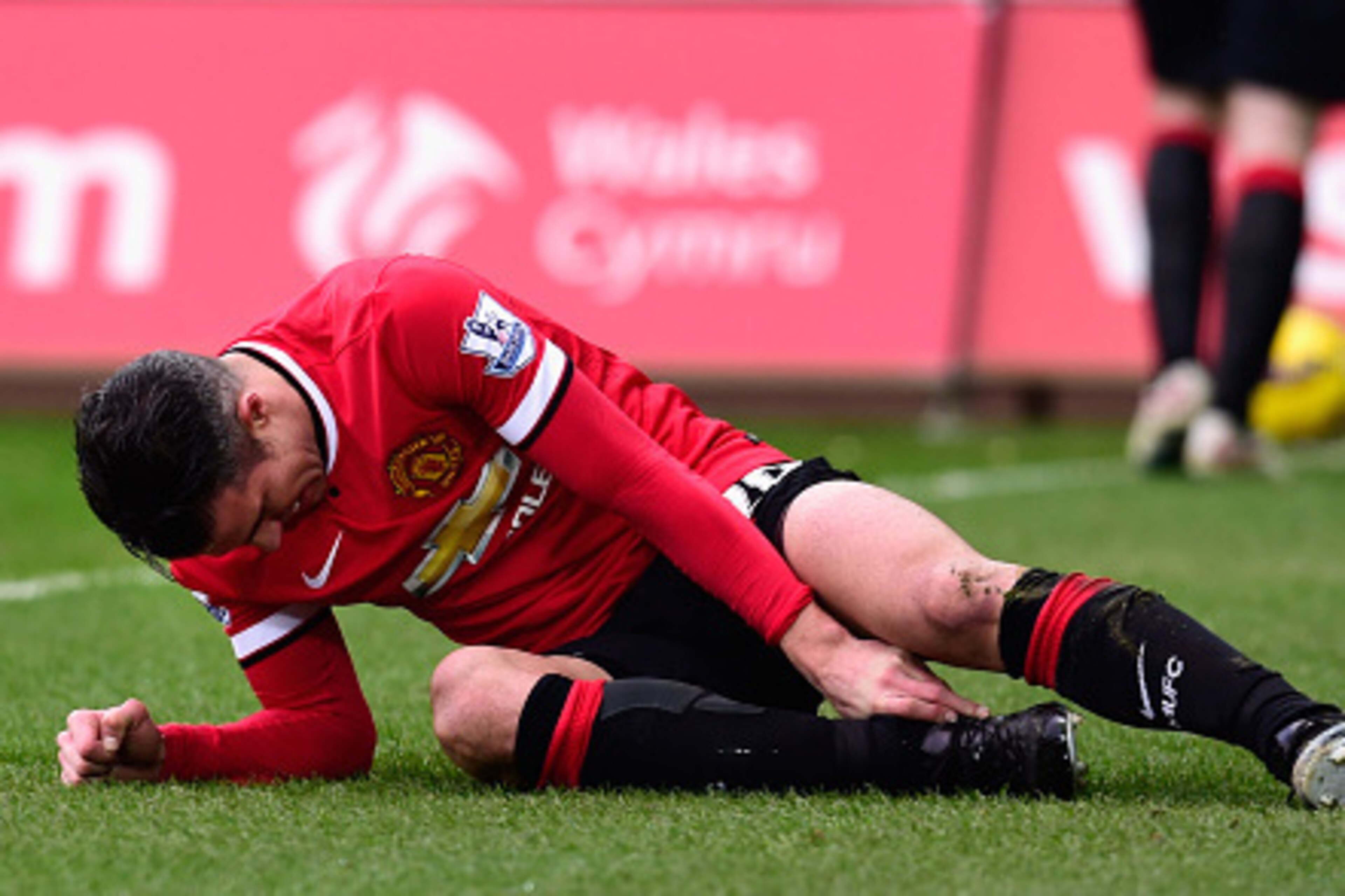 SWANSEA, WALES - FEBRUARY 21:  Robin Van Persie  of Manchester United lies injured during the Barclays Premier League match between Swansea City and Manchester United at Liberty Stadium on February 21, 2015 in Swansea, Wales.  (Photo by Stu Forster/Getty 