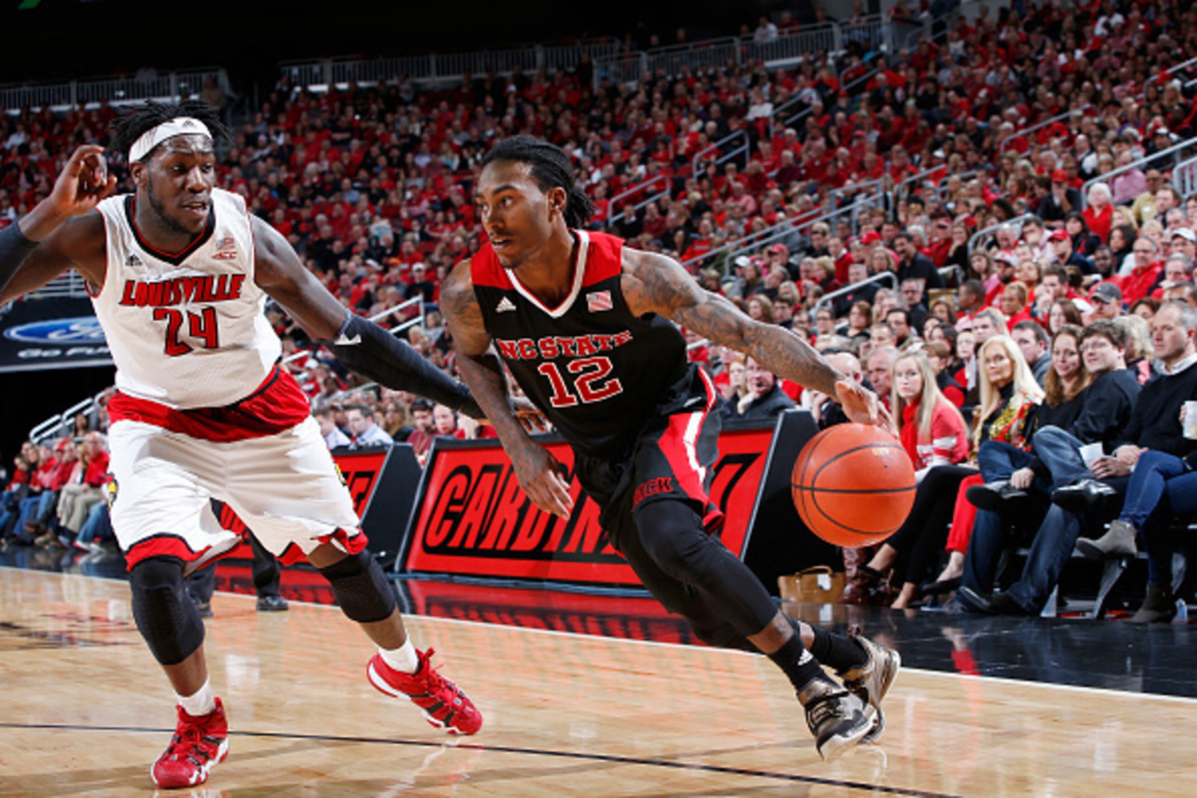 LOUISVILLE, KY - FEBRUARY 14: Anthony Barber #12 of the North Carolina State Wolfpack drives to the basket against Montrezl Harrell #24 of the Louisville Cardinals during the game at KFC Yum! Center on February 14, 2015 in Louisville, Kentucky. North Caro