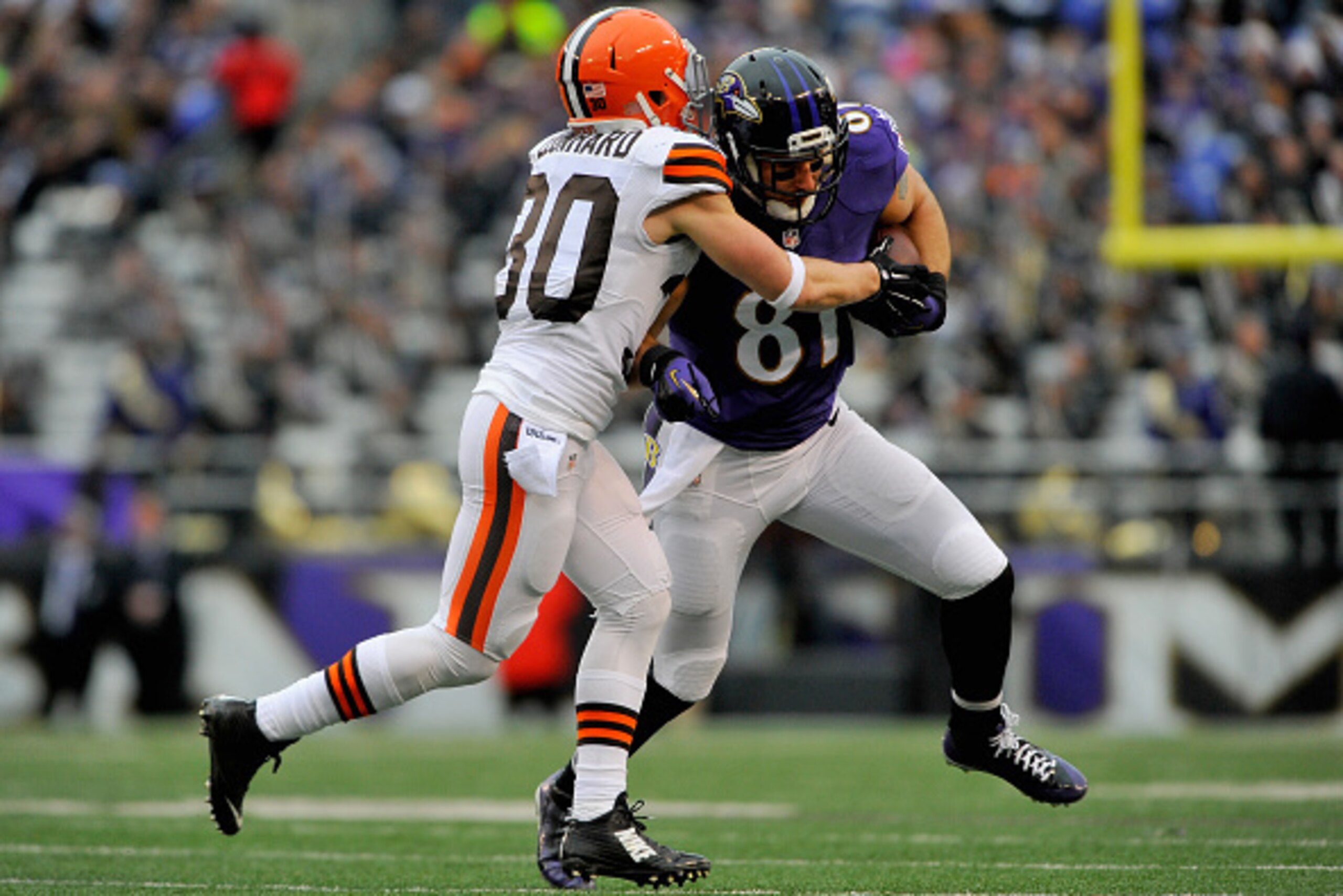 BALTIMORE, MD - DECEMBER 28:  Tight end Owen Daniels #81 of the Baltimore Ravens is tackled by free safety Jim Leonhard #30 of the Cleveland Browns in the second quarter of a game at M&T Bank Stadium on December 28, 2014 in Baltimore, Maryland.  (Photo by