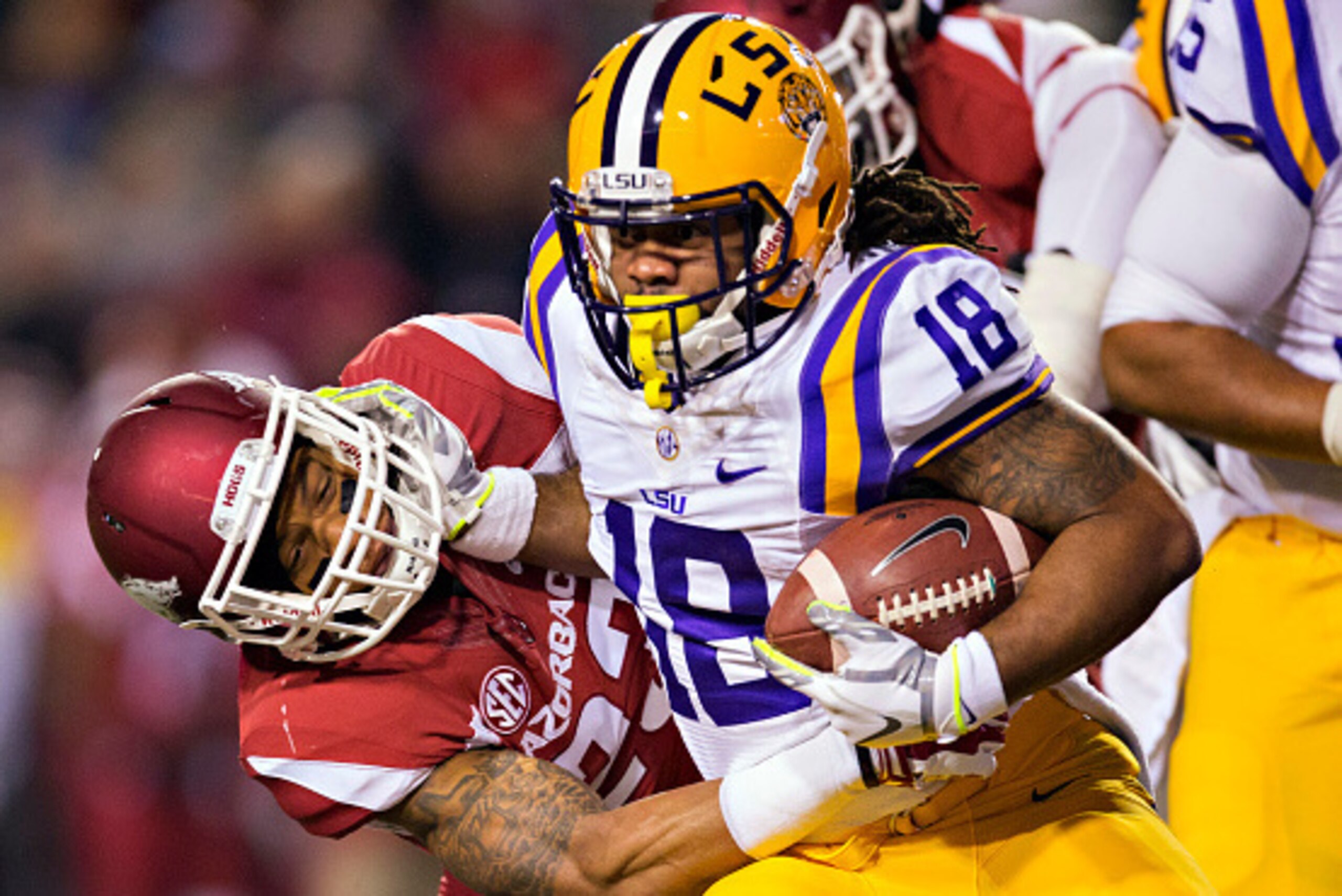 FAYETTEVILLE, AR - NOVEMBER 15:  Terrence Magee #18 of the LSU Tigers stiff arms Tevin Mitchel #23 of the Arkansas Razorbacks at Razorback Stadium on November 15, 2014 in Fayetteville, Arkansas.  (Photo by Wesley Hitt/Getty Images)