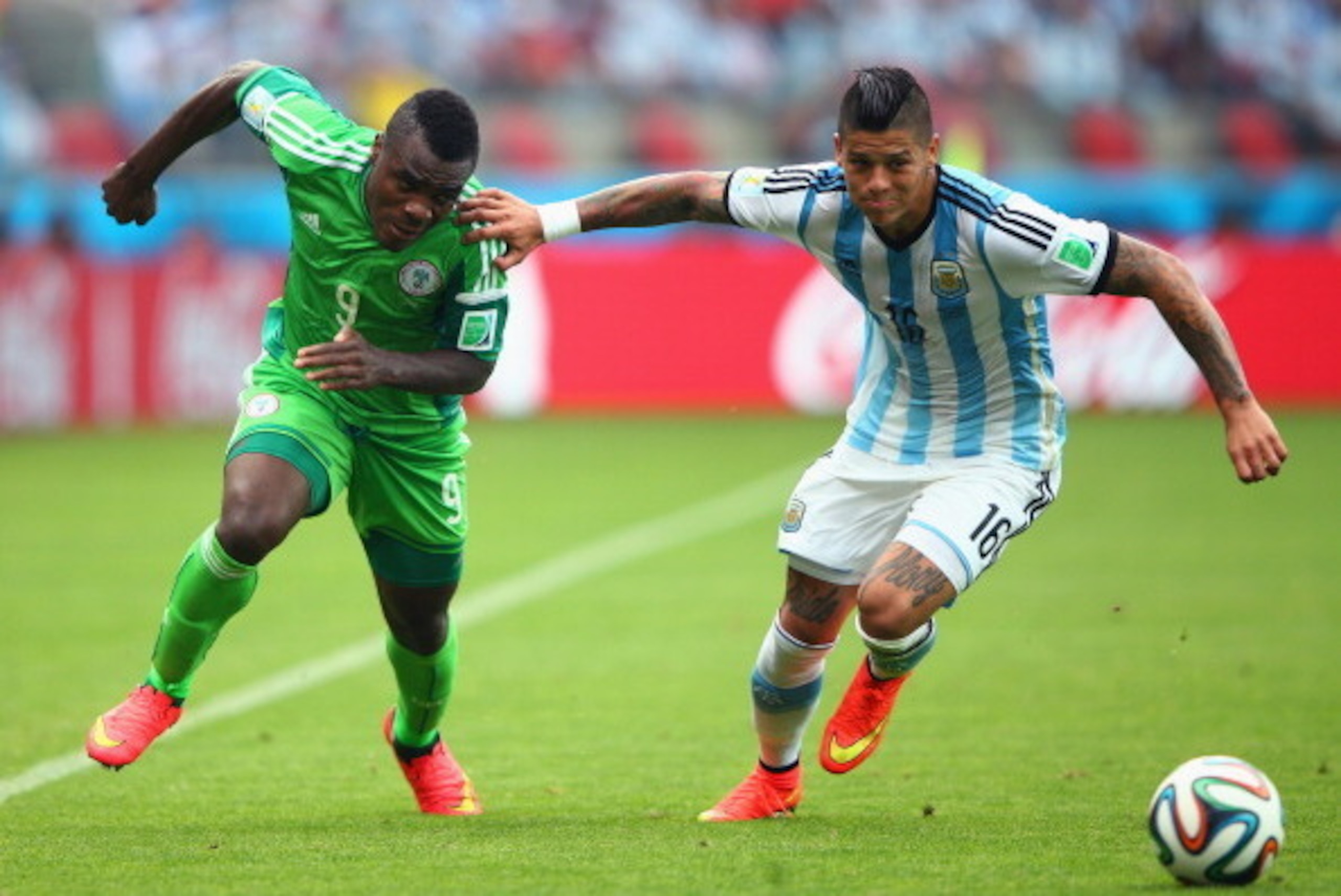 PORTO ALEGRE, BRAZIL - JUNE 25: Marcos Rojo of Argentina competes for the ball with Emmanuel Emenike of Nigeria during the 2014 FIFA World Cup Brazil Group F match between Nigeria and Argentina at Estadio Beira-Rio on June 25, 2014 in Porto Alegre, Brazil