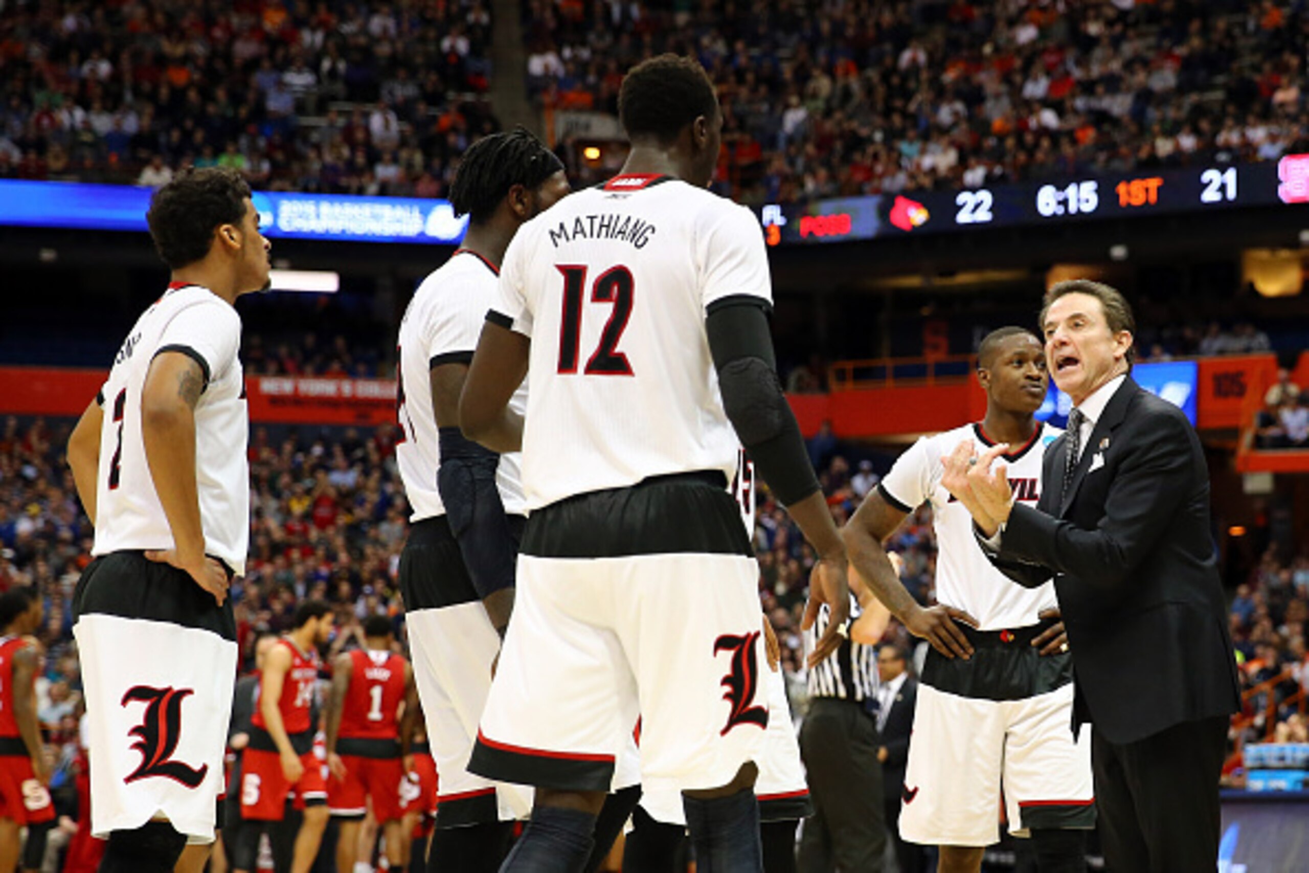 SYRACUSE, NY - MARCH 27:  Head coach Rick Pitino (R) of the Louisville Cardinals talks with his team in the first half of the game anc during the East Regional Semifinal of the 2015 NCAA Men's Basketball Tournament at the Carrier Dome on March 27, 2015 in