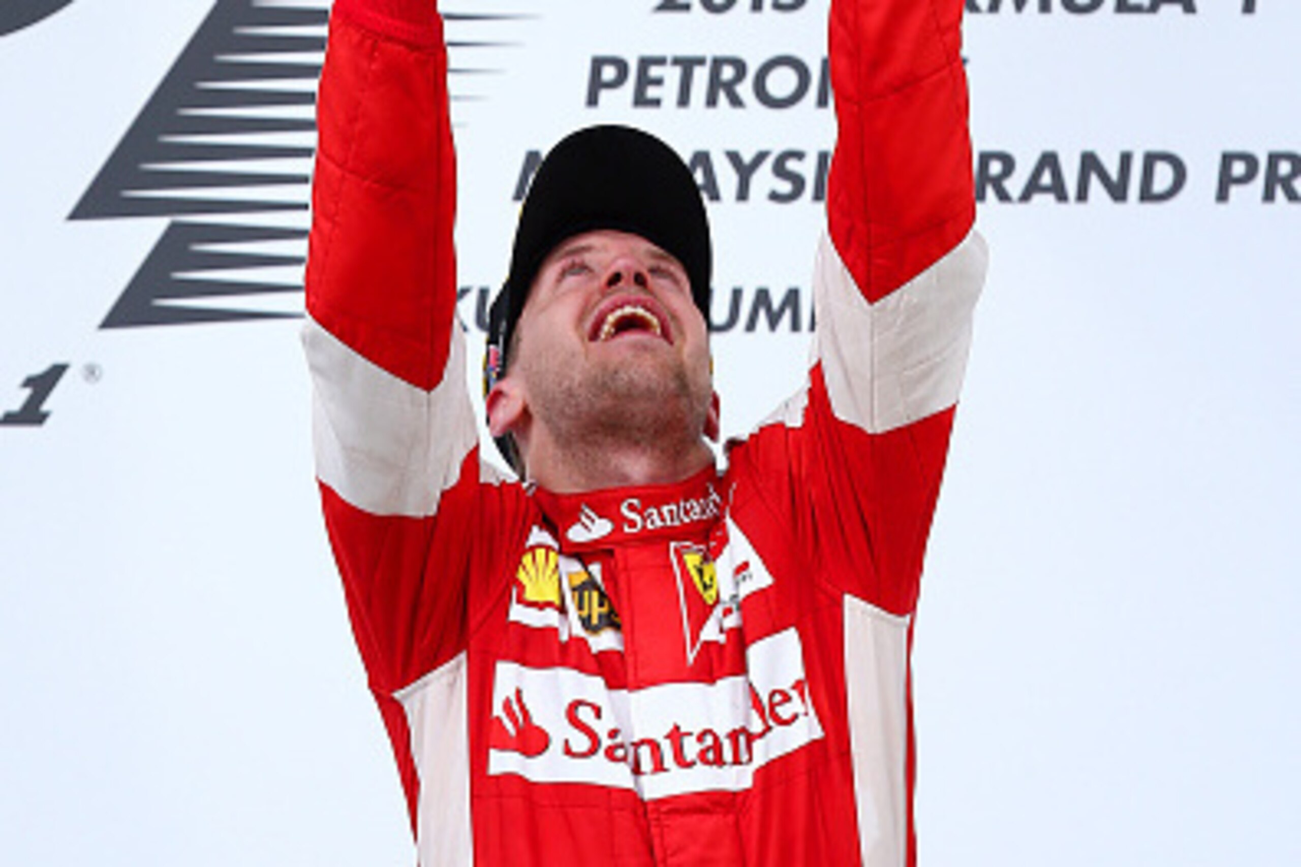KUALA LUMPUR, MALAYSIA - MARCH 29:  Sebastian Vettel of Germany and Ferrari celebrates with the trophy on the podium after winning the Malaysia Formula One Grand Prix at Sepang Circuit on March 29, 2015 in Kuala Lumpur, Malaysia.  (Photo by Mark Thompson/