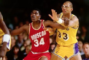 LOS ANGELES - 1986:  Hakeem Olajuwon #34 of the Houston Rockets battles for position against Kareem Abdul-Jabbar #33 of the Los Angeles Lakers during an NBA game at the Forum circa 1986 in Los Angeles, California.  NOTE TO USER: User expressly acknowledge