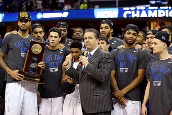 CLEVELAND, OH - MARCH 28:  Head coach John Calipari of the Kentucky Wildcats looks on with his team and their trophy after defeating the Notre Dame Fighting Irish during the Midwest Regional Final of the 2015 NCAA Men's Basketball tournament at Quicken Lo