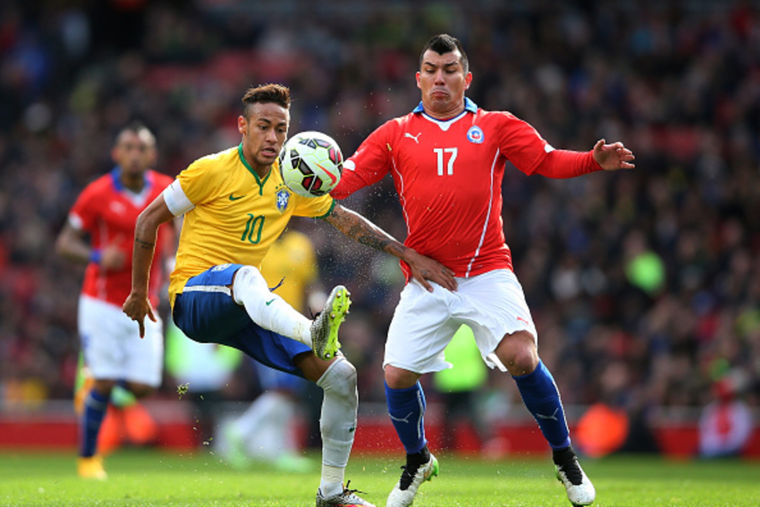 LONDON, ENGLAND - MARCH 29:  Neymar of Brazil controls the ball under pressure from Gary Medel of Chile during the international friendly match between Brazil and Chile at the Emirates Stadium on March 29, 2015 in London, England.  (Photo by Paul Gilham/G