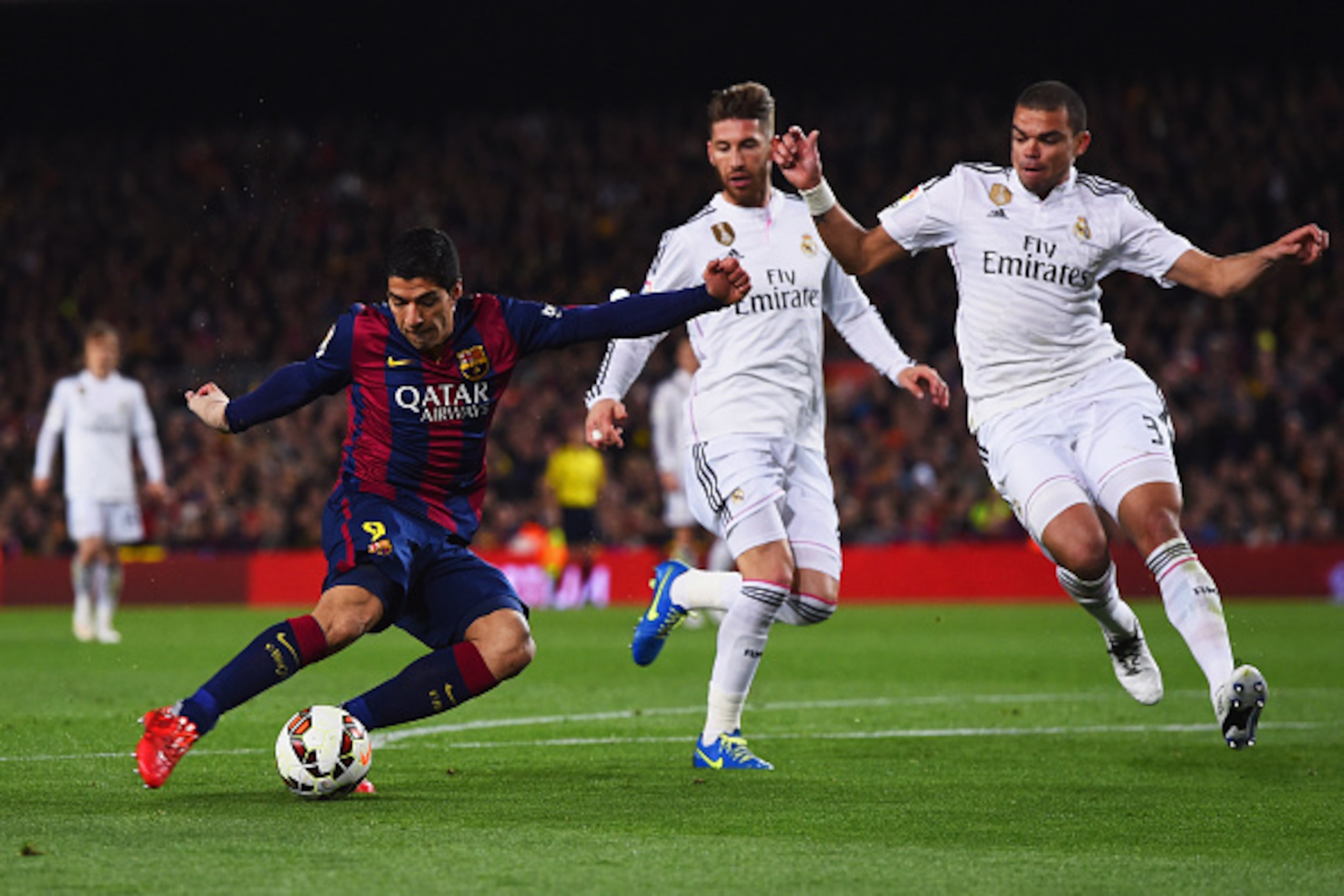BARCELONA, SPAIN - MARCH 22:  Luis Suarez of Barcelona shoots past Sergio Ramos and Pepe of Real Madrid CF to score their second goal during the La Liga match between FC Barcelona and Real Madrid CF at Camp Nou on March 22, 2015 in Barcelona, Spain.  (Pho