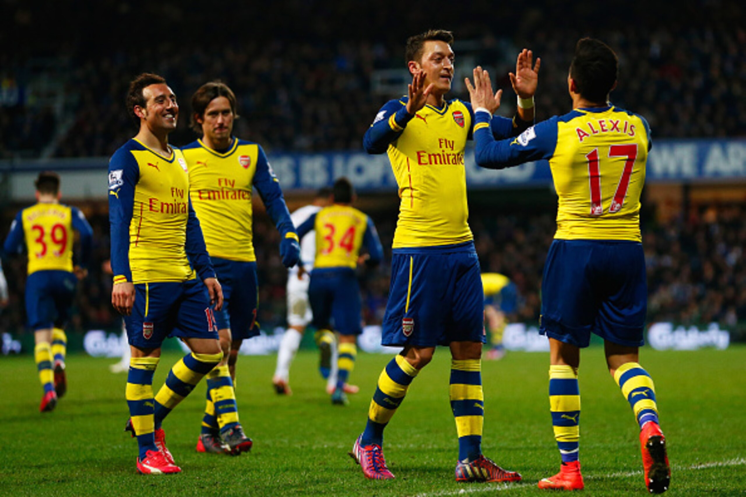 LONDON, ENGLAND - MARCH 04:  Alexis Sanchez of Arsenal (17) celebrates with Mesut Oezil as he scores their second goal during the Barclays Premier League match between Queens Park Rangers and Arsenal at Loftus Road on March 4, 2015 in London, England.  (P
