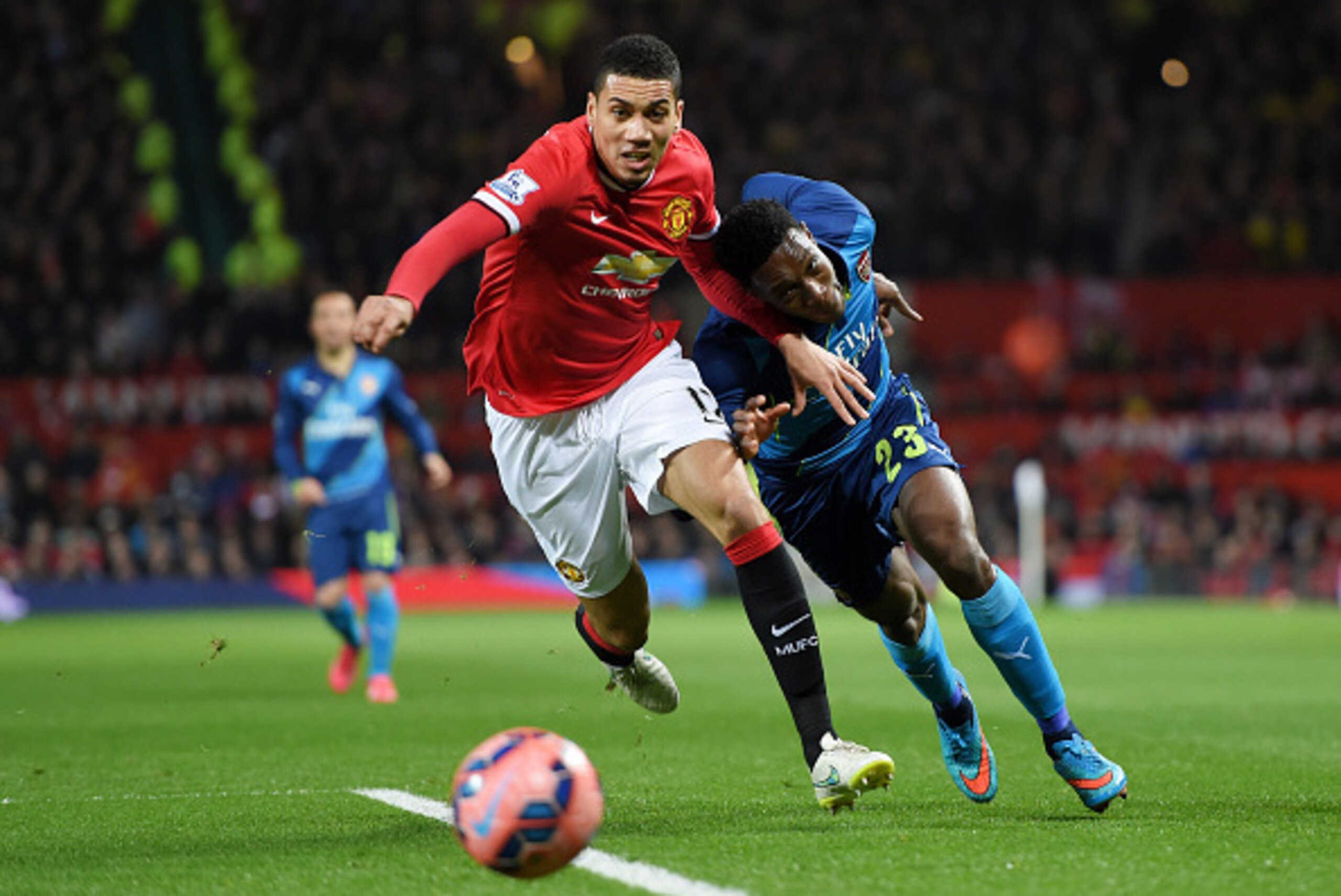 MANCHESTER, ENGLAND - MARCH 09:  Chris Smalling of Manchester United and Danny Welbeck of Arsenal battle for the ball during the FA Cup Quarter Final match between Manchester United and Arsenal at Old Trafford on March 9, 2015 in Manchester, England.  (Ph