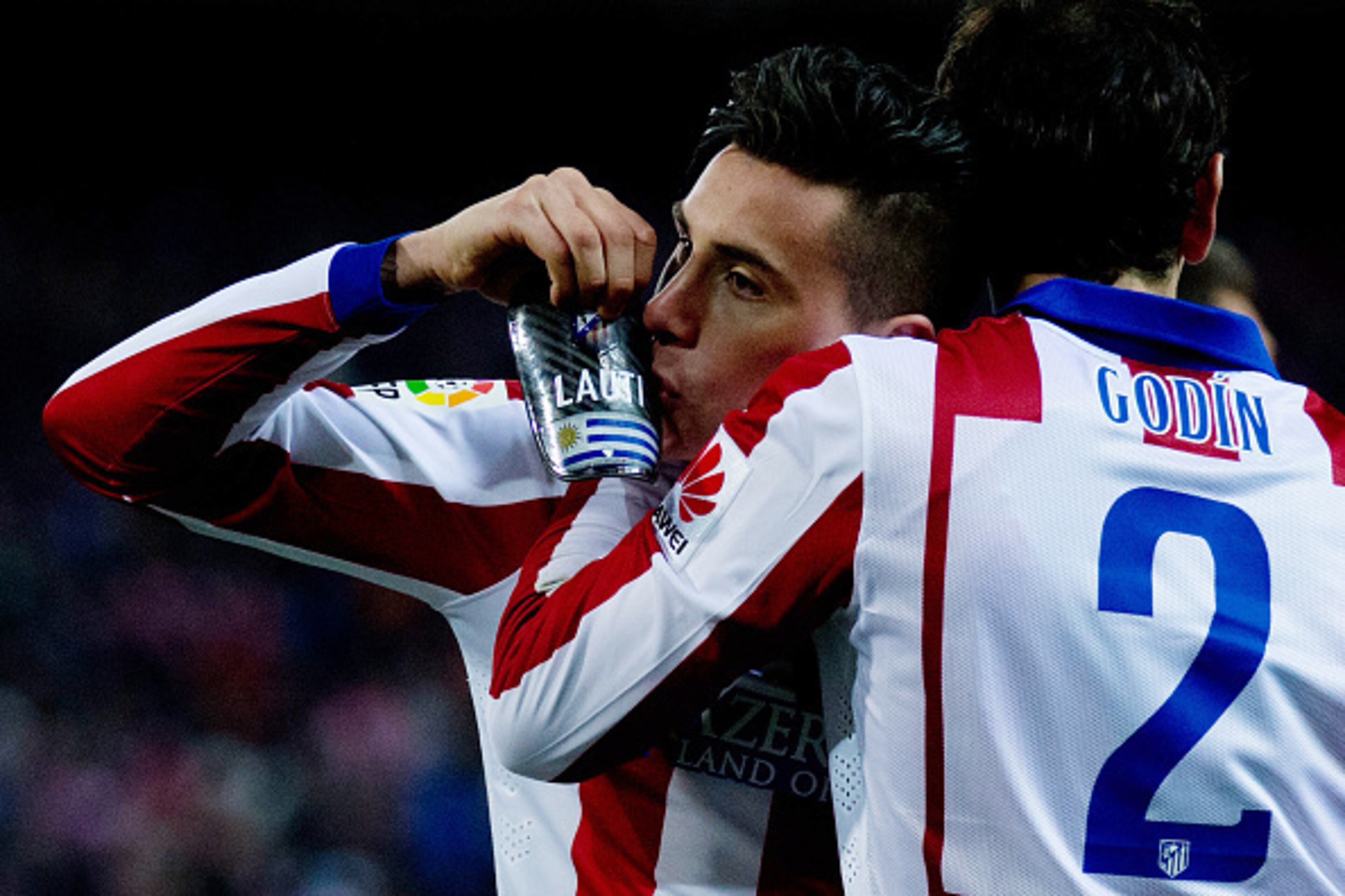 MADRID, SPAIN - JANUARY 07: Jose Maria Gimenez (L) of Atletico de Madrid kisse his shinpad as he celebrates scoring hs second goal embraced to his teammate Diego Godin (R) during the Copa del Rey Round of 16  first leg match between Club Atletico de Madri