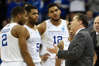 Mar 21, 2015; Louisville, KY, USA; Kentucky Wildcats head coach John Calipari talks with his players during the second half against the Cincinnati Bearcats in the third round of the 2015 NCAA Tournament at KFC Yum! Center. Kentucky defeated Cincinnati  64