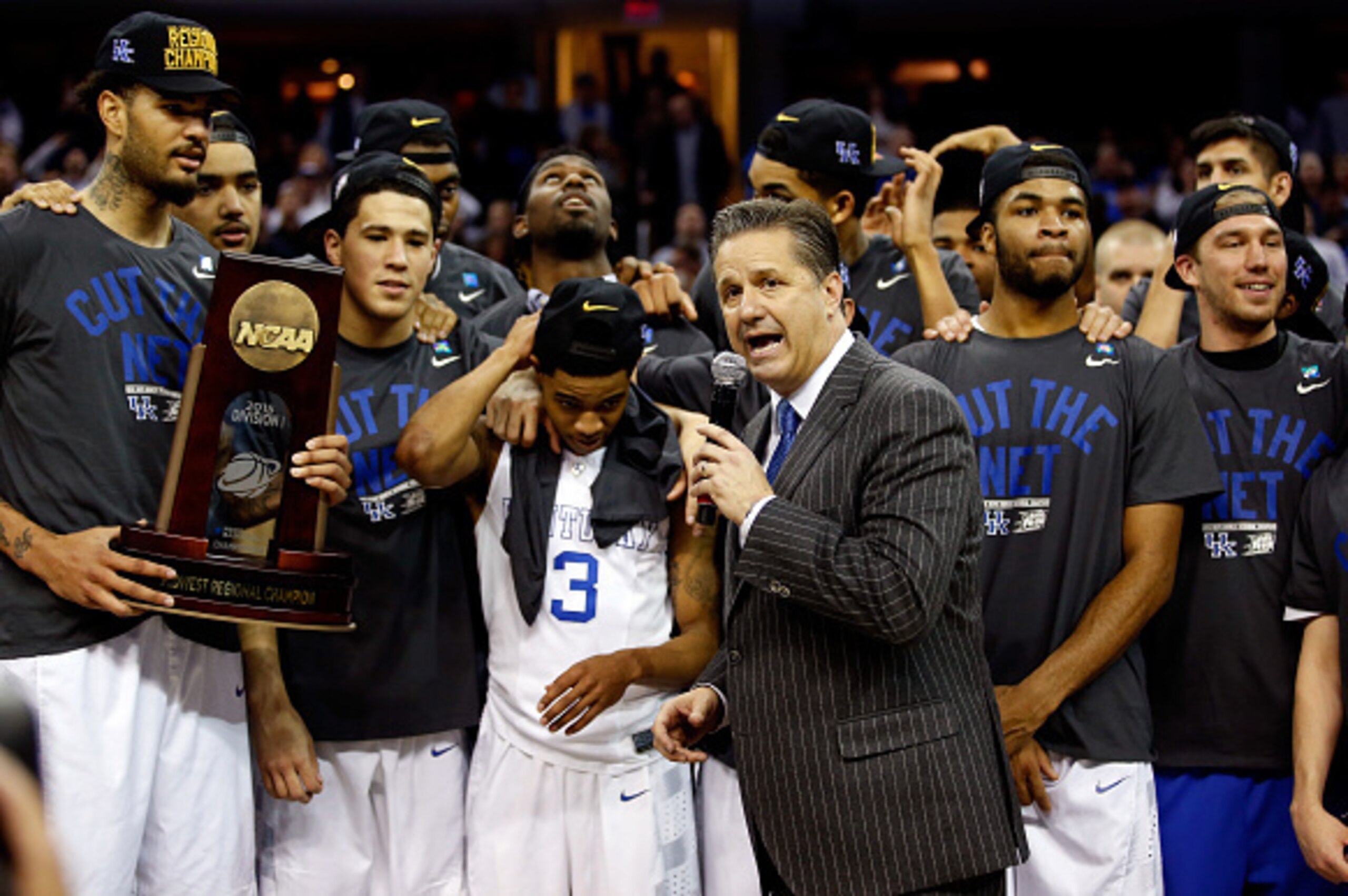 CLEVELAND, OH - MARCH 28:  Head coach John Calipari of the Kentucky Wildcats looks on with his team and their trophy after defeating the Notre Dame Fighting Irish during the Midwest Regional Final of the 2015 NCAA Men's Basketball tournament at Quicken Lo