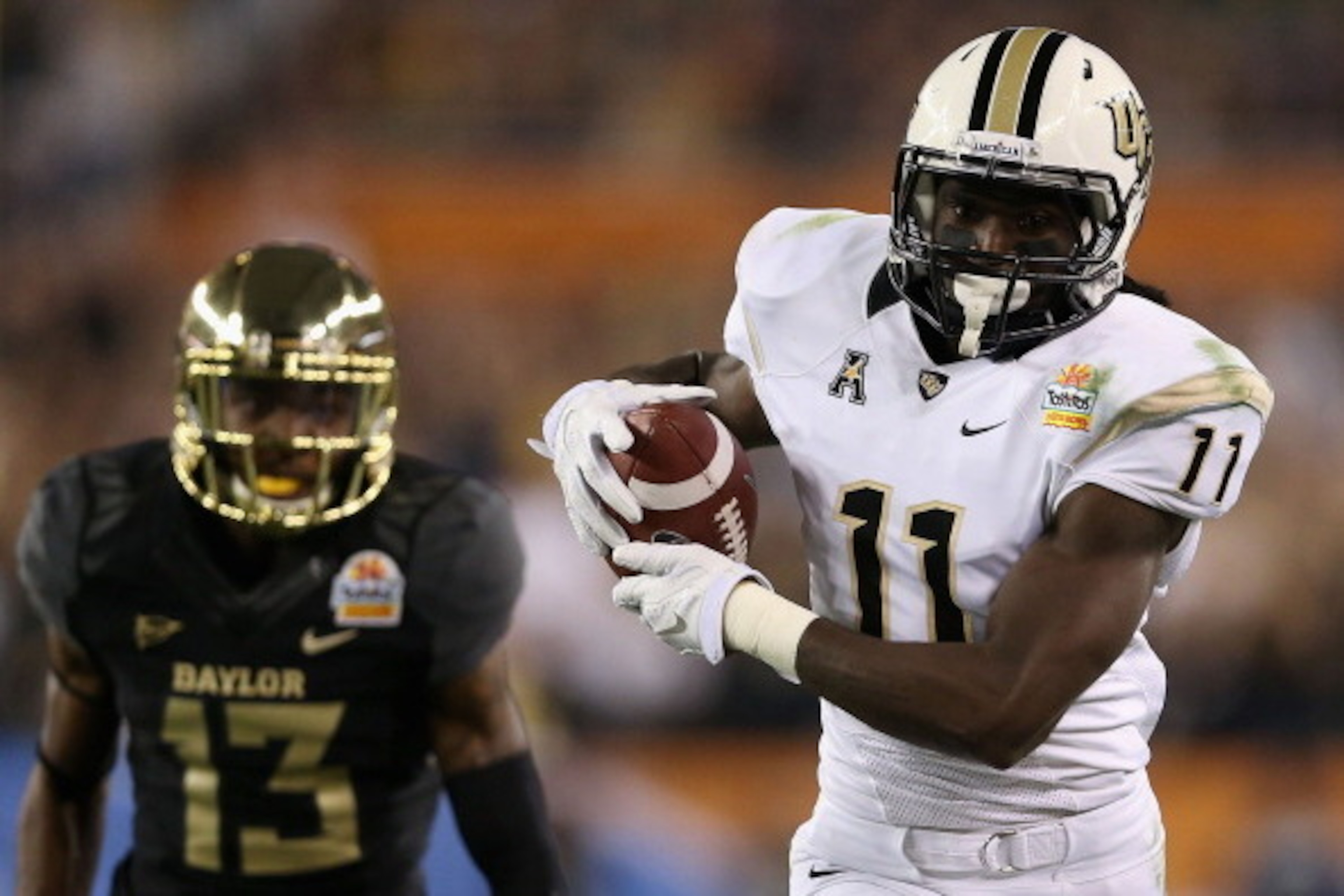 GLENDALE, AZ - JANUARY 01:  Wide receiver Breshad Perriman #11 of the UCF Knights runs with the football past safety Terrell Burt #13 of the Baylor Bears during the Tostitos Fiesta Bowl at University of Phoenix Stadium on January 1, 2014 in Glendale, Ariz