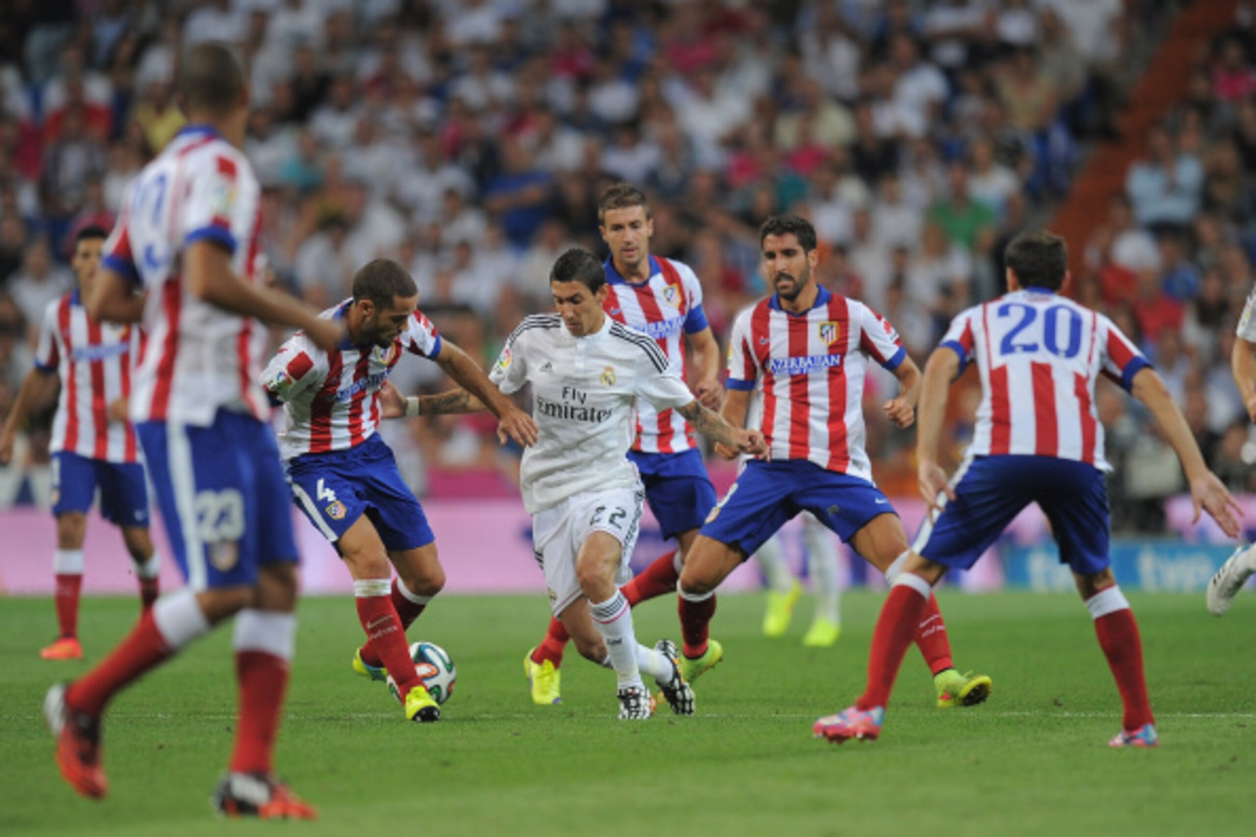 MADRID, SPAIN - AUGUST 19:  Angel di Maria of Real Madrid is surrounded by Club Atletico de Madrid players during the Supercopa first leg match between Real Madrid and Club Atletico de Madrid     at Estadio Santiago Bernabeu on August 19, 2014 in Madrid, 