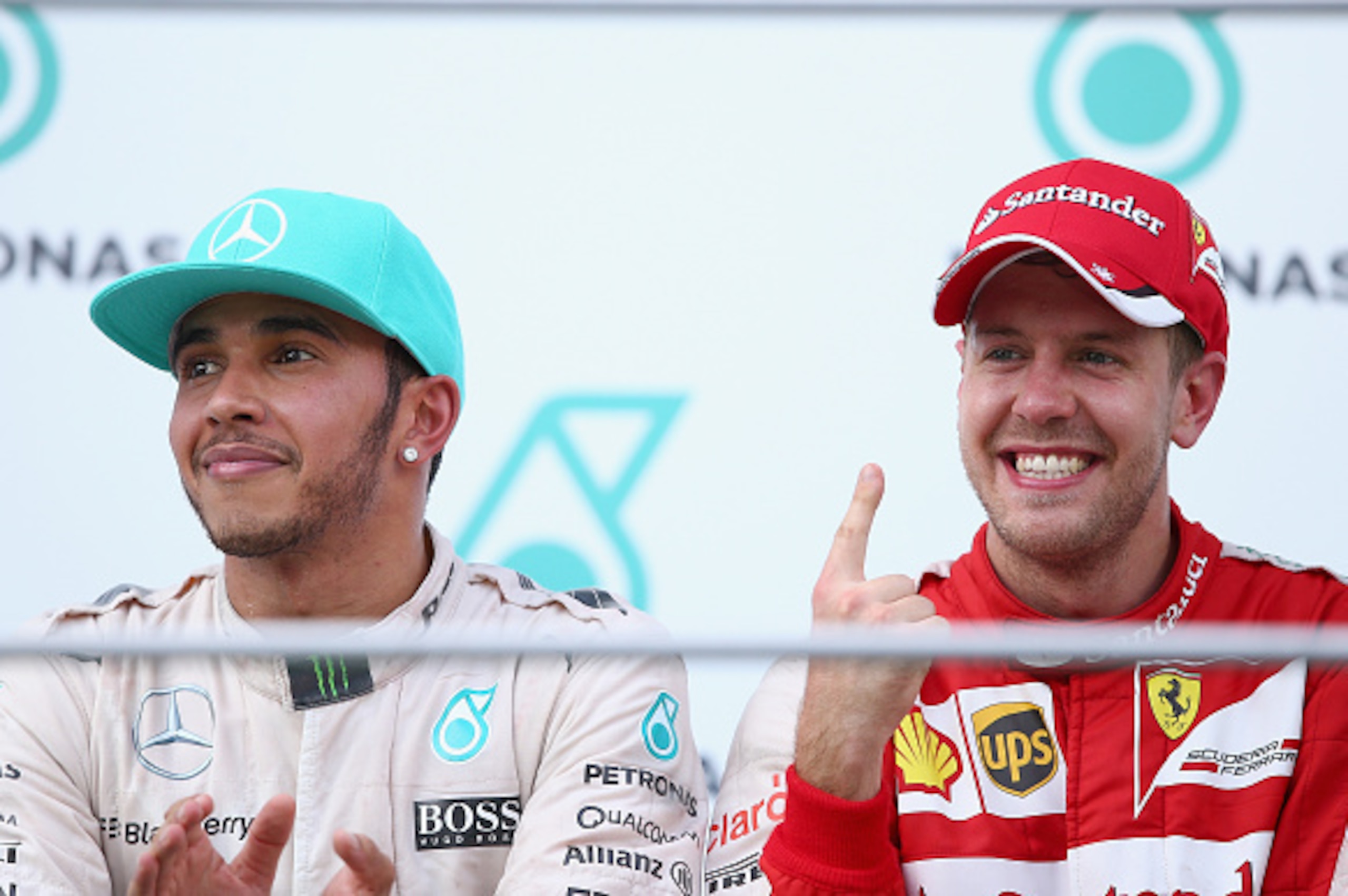 KUALA LUMPUR, MALAYSIA - MARCH 29:  Sebastian Vettel of Germany and Ferrari celebrates on the podium next to Lewis Hamilton of Great Britain and Mercedes GP after winning the Malaysia Formula One Grand Prix at Sepang Circuit on March 29, 2015 in Kuala Lum