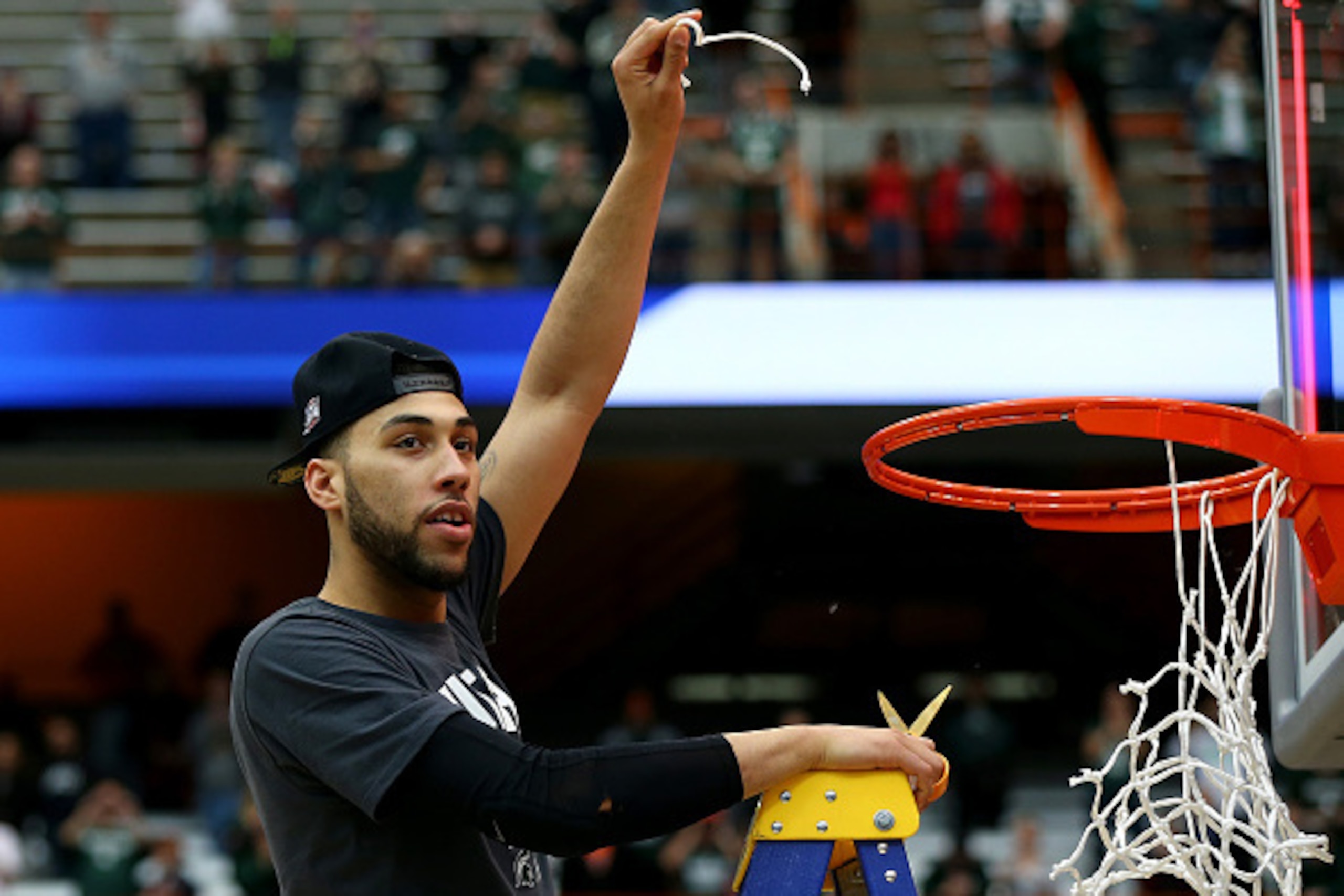 SYRACUSE, NY - MARCH 29:  Denzel Valentine #45 of the Michigan State Spartans celebrates by cutting down the net after defeating the Louisville Cardinals 76 to 70 in overtime of the East Regional Final of the 2015 NCAA Men's Basketball Tournament at Carri