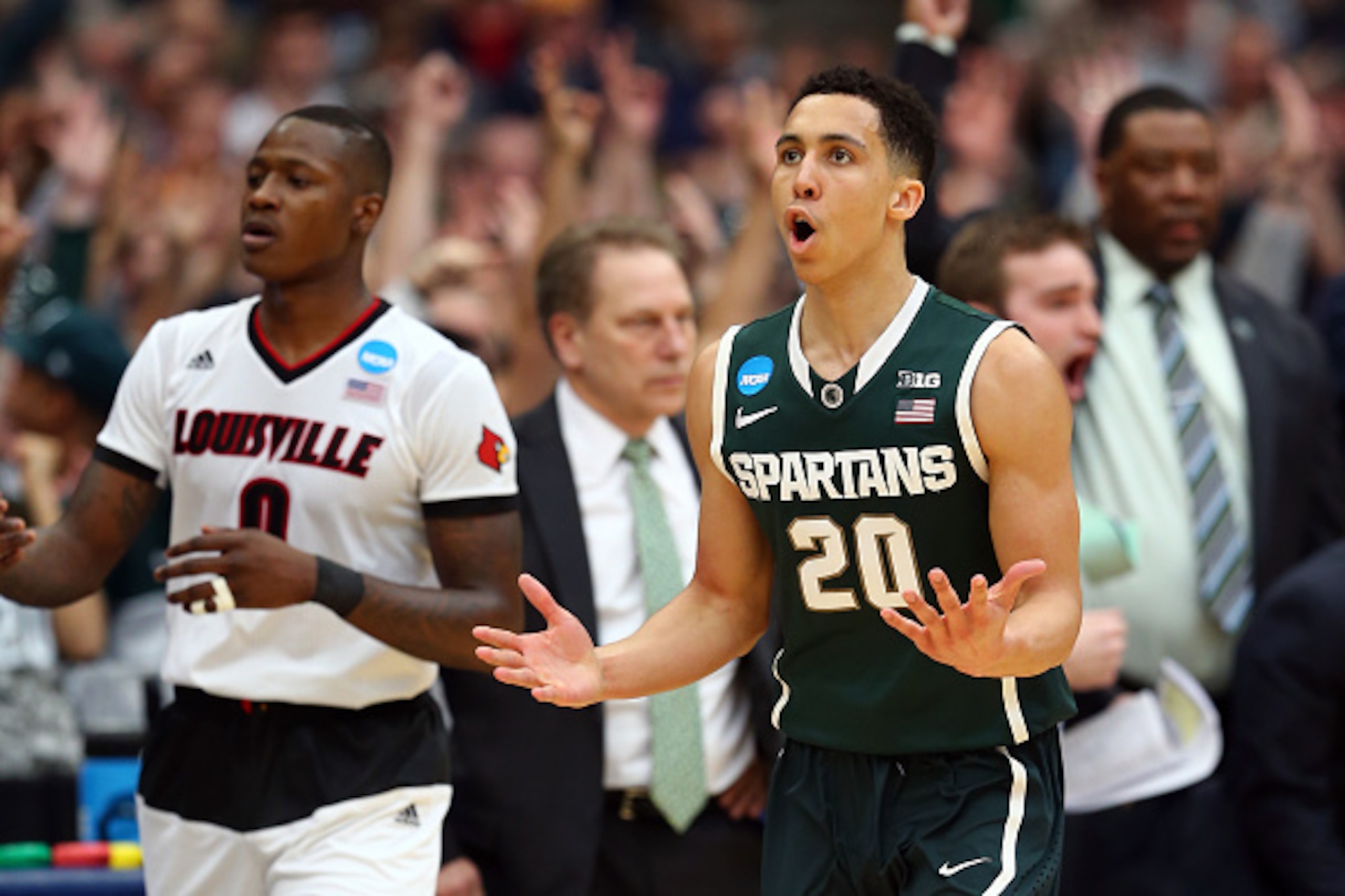 SYRACUSE, NY - MARCH 29:  Travis Trice #20 of the Michigan State Spartans reacts in the second half of the game against Terry Rozier #0 of the Louisville Cardinals during the East Regional Final of the 2015 NCAA Men's Basketball Tournament at Carrier Dome