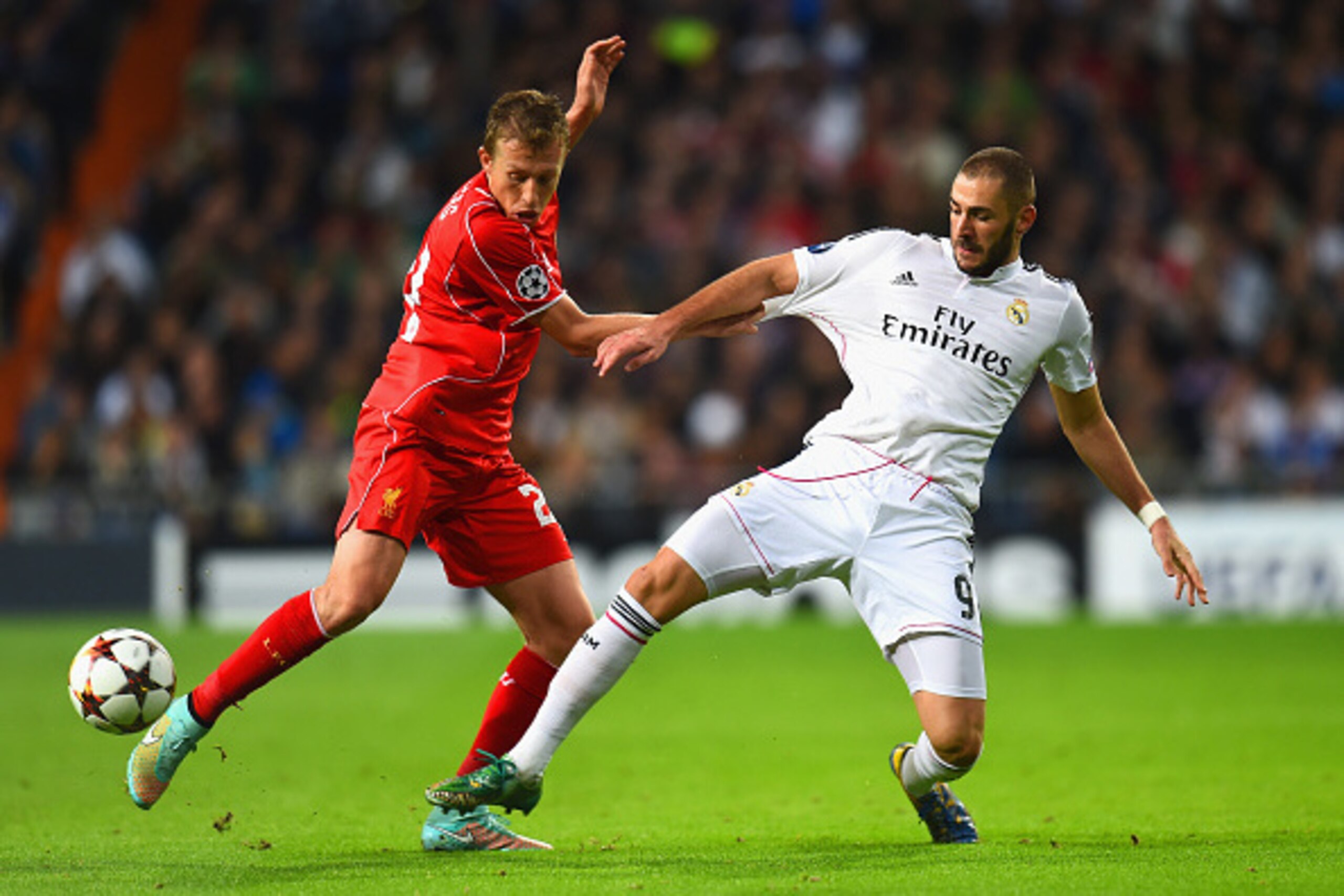 MADRID, SPAIN - NOVEMBER 04:  Lucas Leiva of Liverpool is challneged by Karim Benzema of Real Madrid CF during the UEFA Champions League Group B match between Real Madrid CF and Liverpool FC at Estadio Santiago Bernabeu on November 4, 2014 in Madrid, Spai