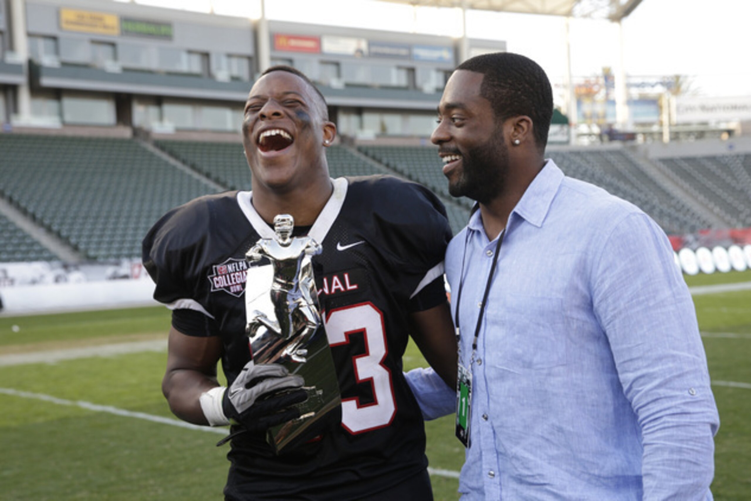 Terrell Watson, with NFL running back Andre Williams, holds his MVP trophy after the NFLPA Collegiate Bowl in January.