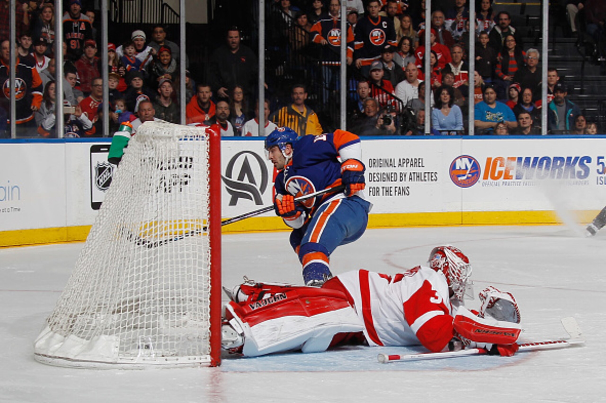 UNIONDALE, NY - MARCH 29: Cal Clutterbuck #15 of the New York Islanders scores at 3:57 of the second period against Jimmy Howard #35 of the Detroit Red Wings at the Nassau Veterans Memorial Coliseum on March 29, 2015 in Uniondale, New York.  (Photo by Bru