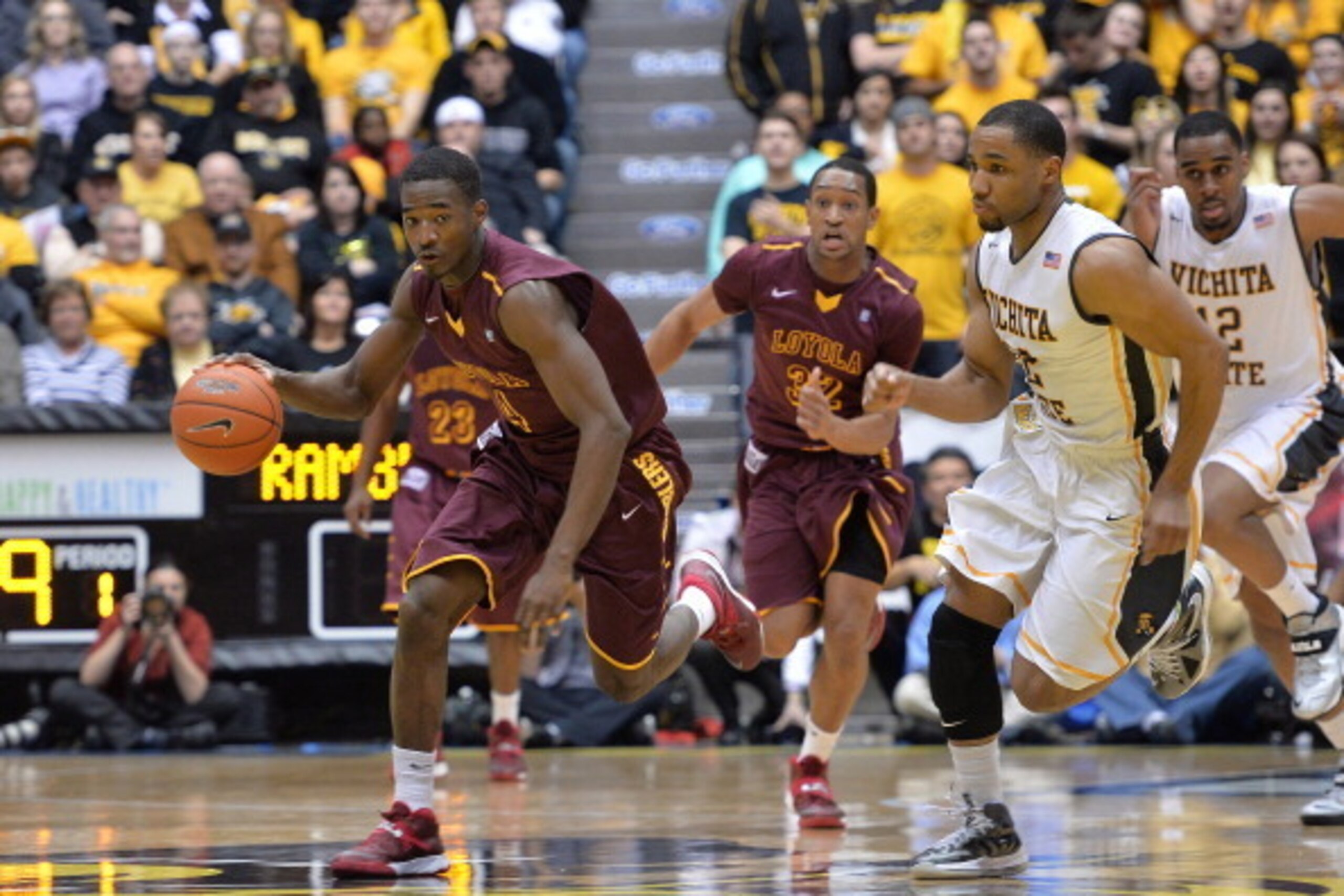 WICHITA, KS - JANUARY 28: Guard Devon Turk #4 of the Loyola-Chicago Ramblers drives the ball up court against guard Tekele Cotton #32 of the Wichita State Shockers during the first half on January 28, 2014 at Charles Koch Arena in Wichita, Kansas. (Phot WICHITA, KS - JANUARY 28: Guard Devon Turk #4 of the Loyola-Chicago Ramblers drives the ball up court against guard Tekele Cotton #32 of the Wichita State Shockers during the first half on January 28, 2014 at Charles Koch Arena in Wichita, Kansas. (Phot