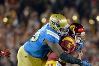 PASADENA, CA - NOVEMBER 22:  Cody Kessler #6 of the USC Trojans is sacked by Ellis McCarthy #90 of the UCLA Bruins during the fourth quarter at the Rose Bowl on November 22, 2014 in Pasadena, California.  (Photo by Harry How/Getty Images)